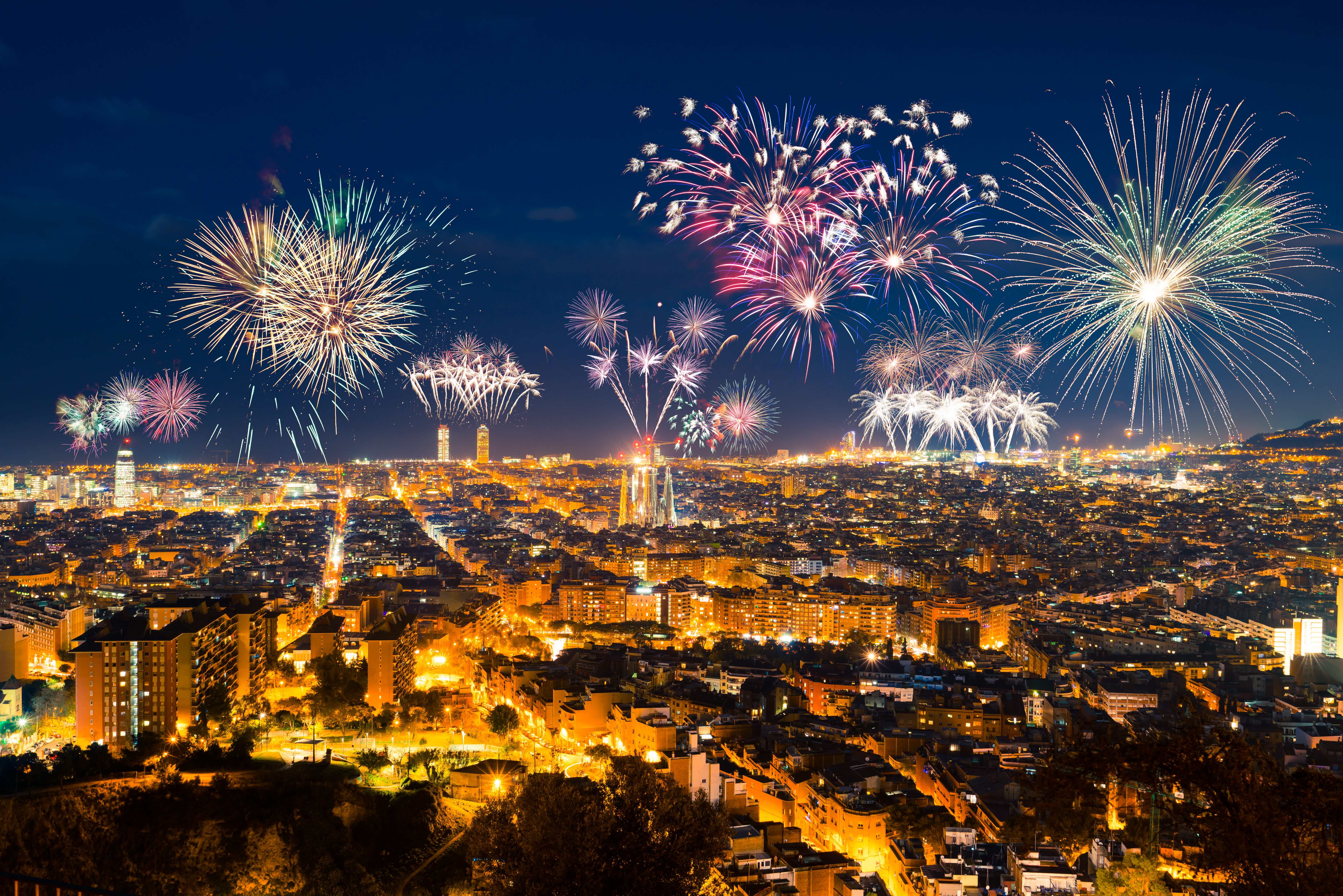 Pragtfuldt fyrværkeri over Barcelonas natlige skyline med Sagrada Familia og byens lys