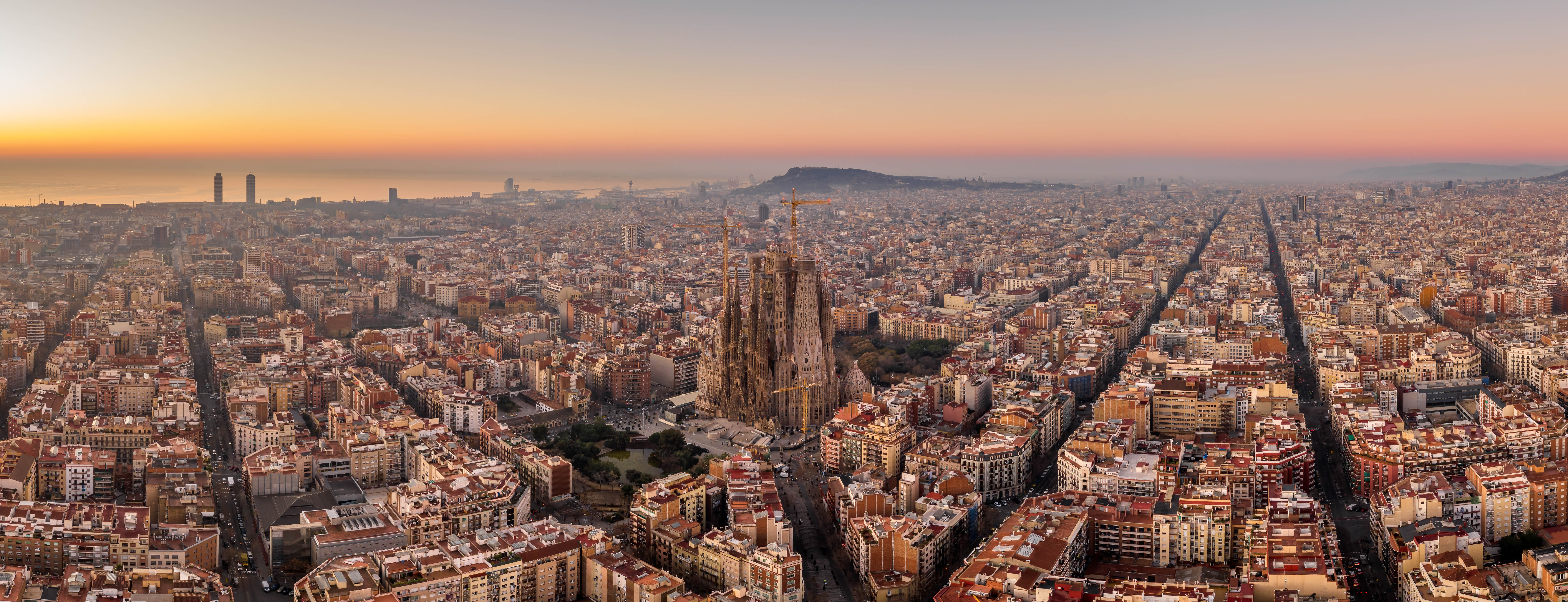 Fantastisk luftpanorama over Barcelona med Sagrada Familia og den gyldne solopgang over Middelhavet, Spanien