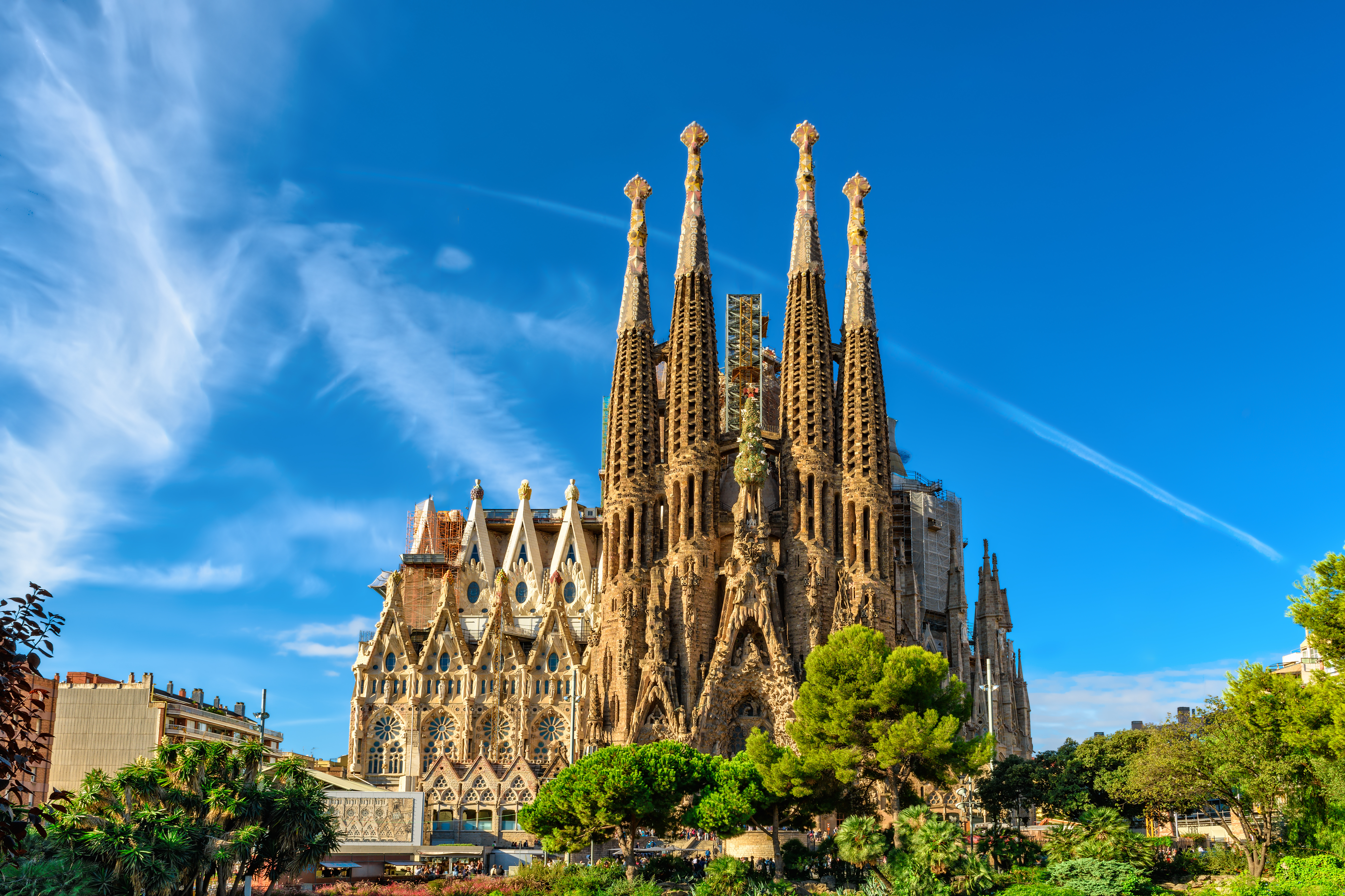 Den smukke Sagrada Familia katedral i Barcelona med Gaudís unikke arkitektoniske stil, høje tårne og detaljerede udskæringer mod blå himmel