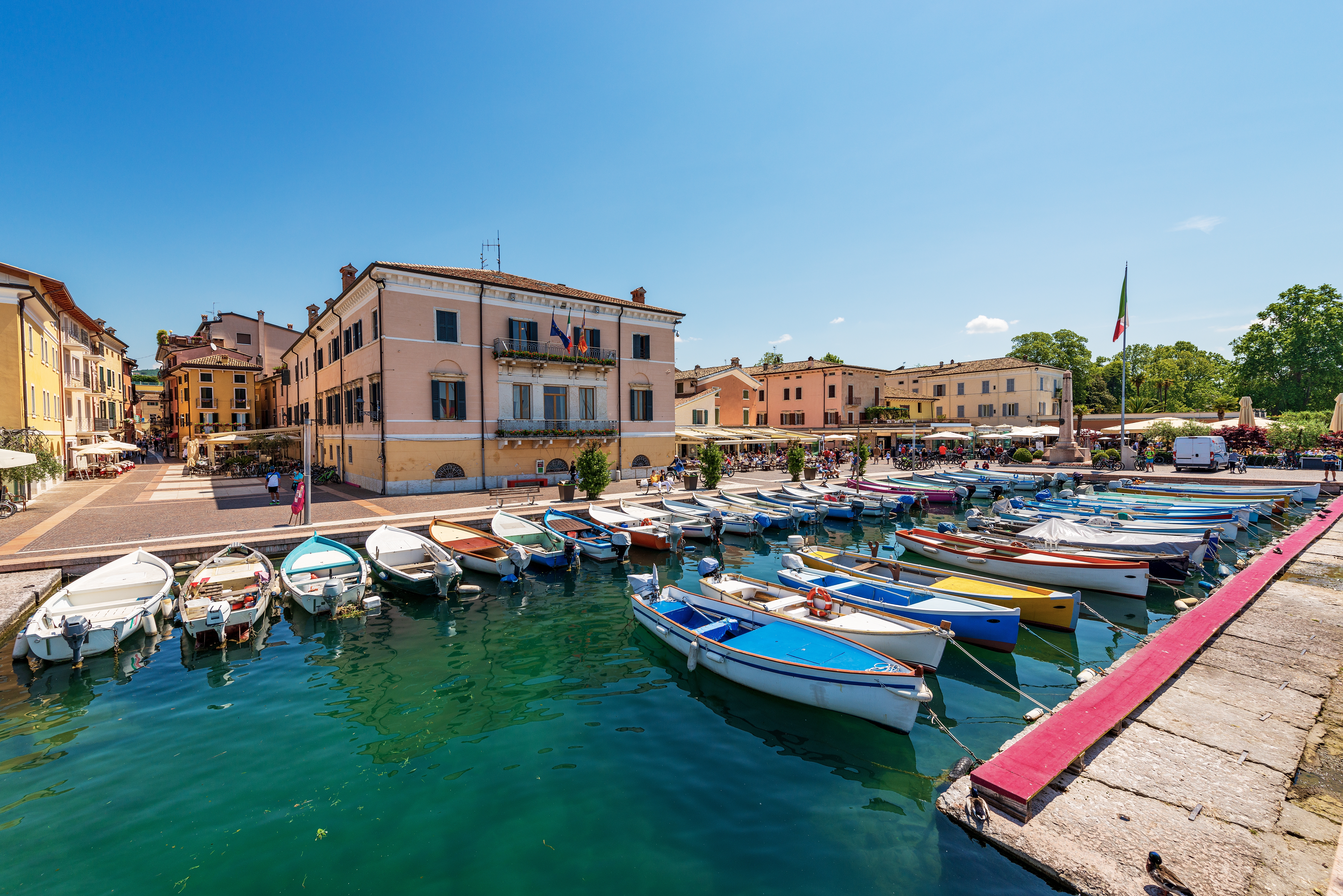 Traditionelle fiskerbåde og lystbåde i den charmerende havn i Bardolino, Italien