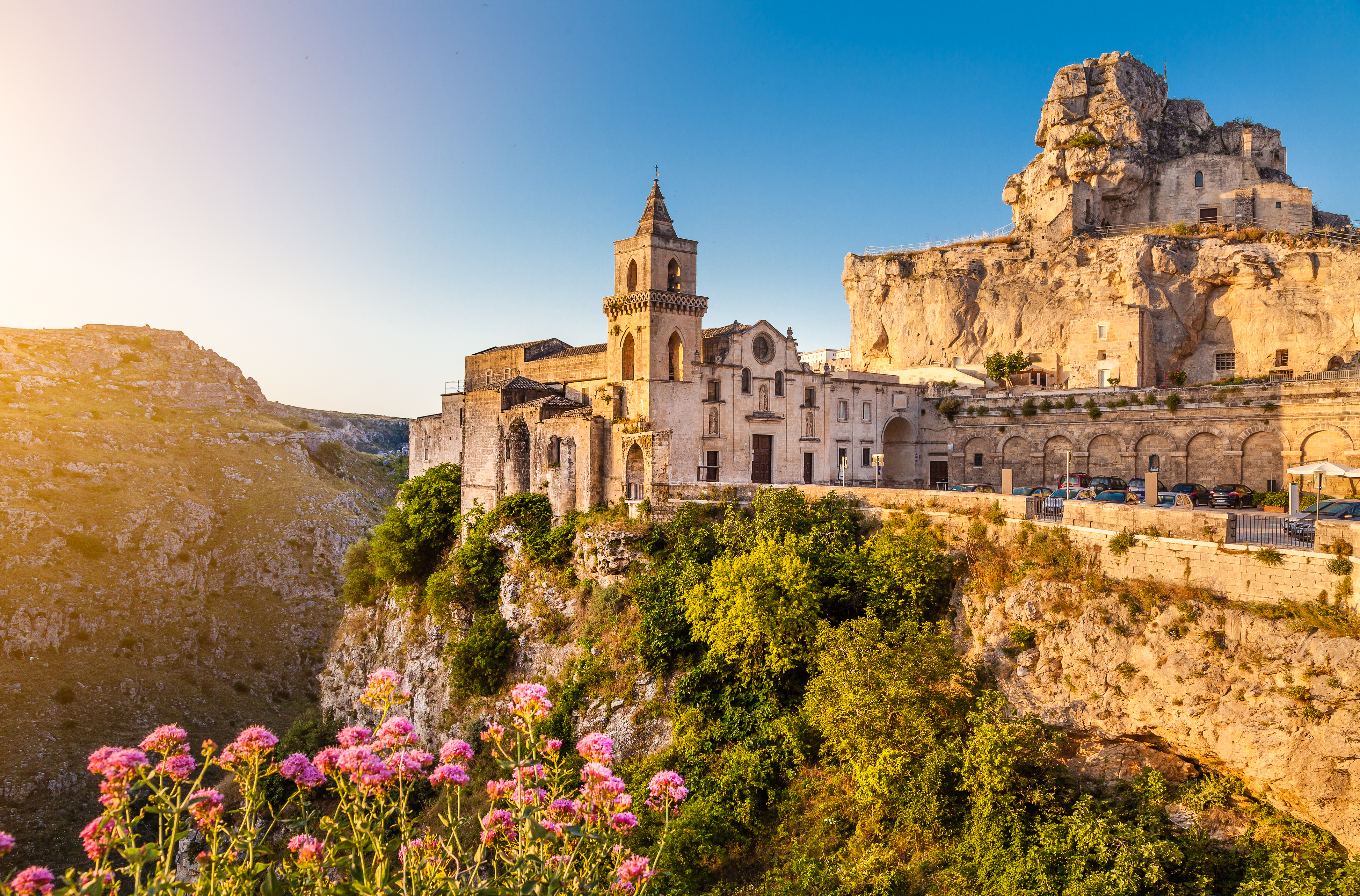 Den fascinerende stenby Matera med sine historiske Sassi-boliger og kirketårn oplyst af den gyldne solopgang i Syditalien