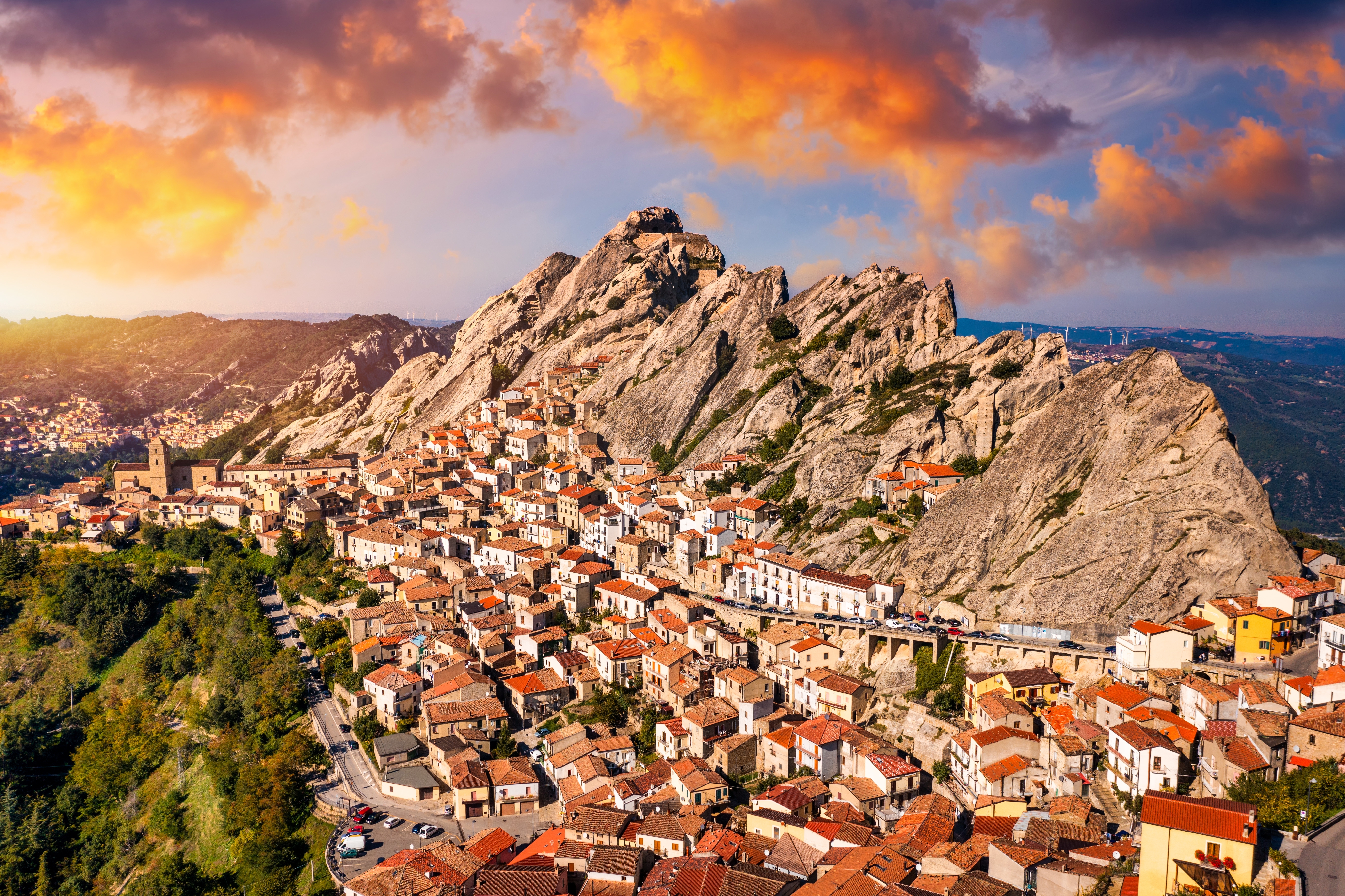 Spektakulært luftfoto af Pietrapertosa, en af Italiens smukkeste bjerglandsbyer i Basilicata, med dramatiske klippetoppe og gyldne solnedgangsskyer