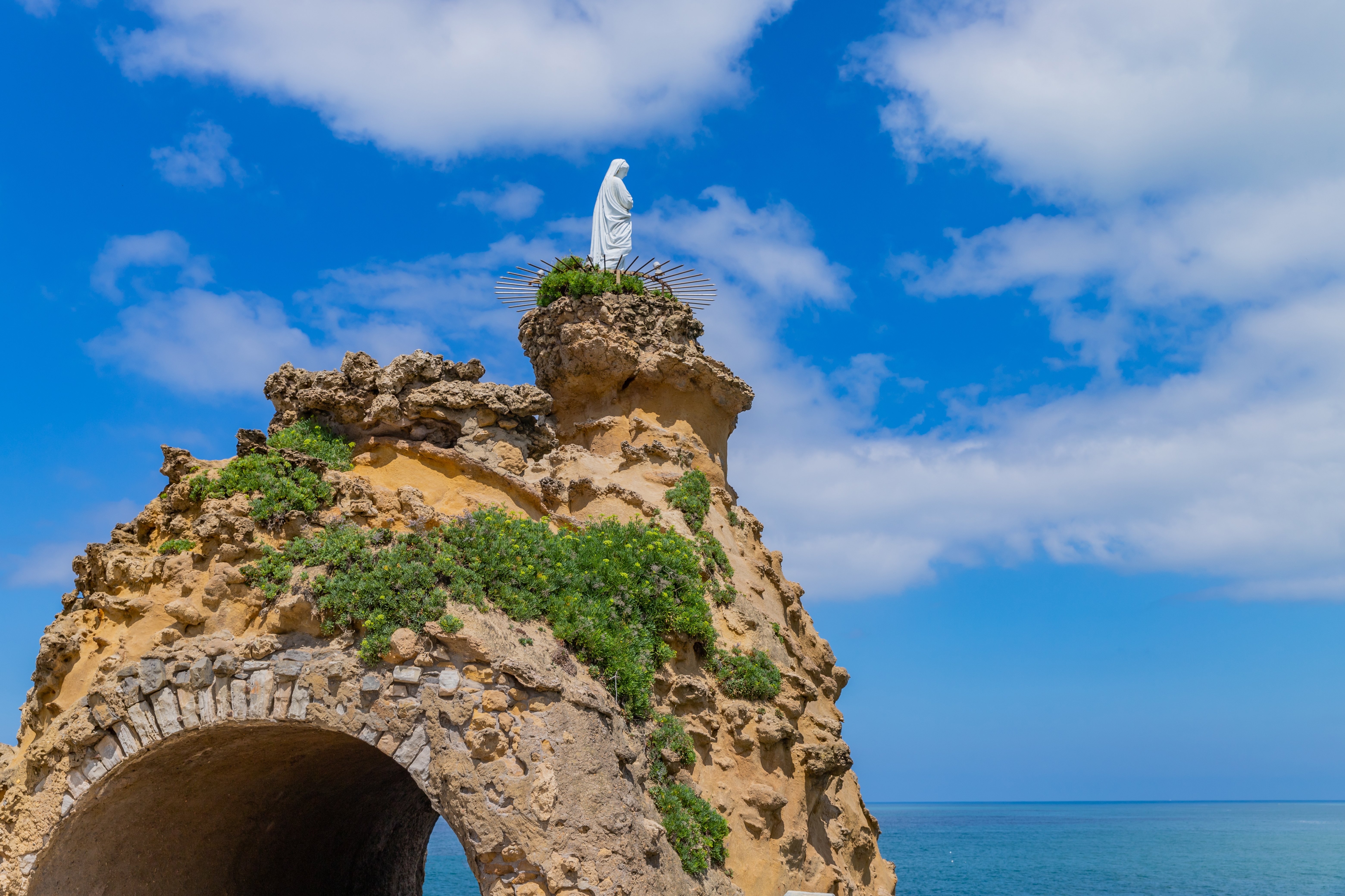 Dramatisk klippeformation med religiøs statue i Biarritz Baskerlandet