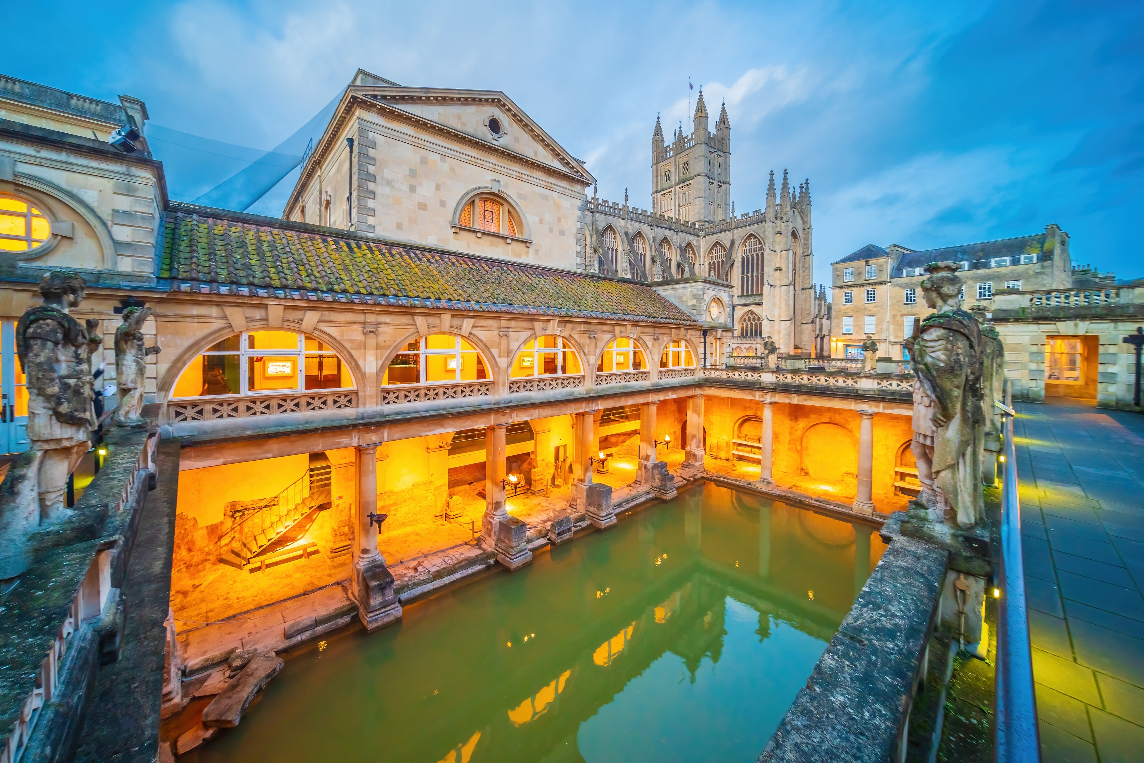 UNESCO-verdensarv: De Romerske Bade i Bath ved tusmørke med det ikoniske Bath Abbey i baggrunden