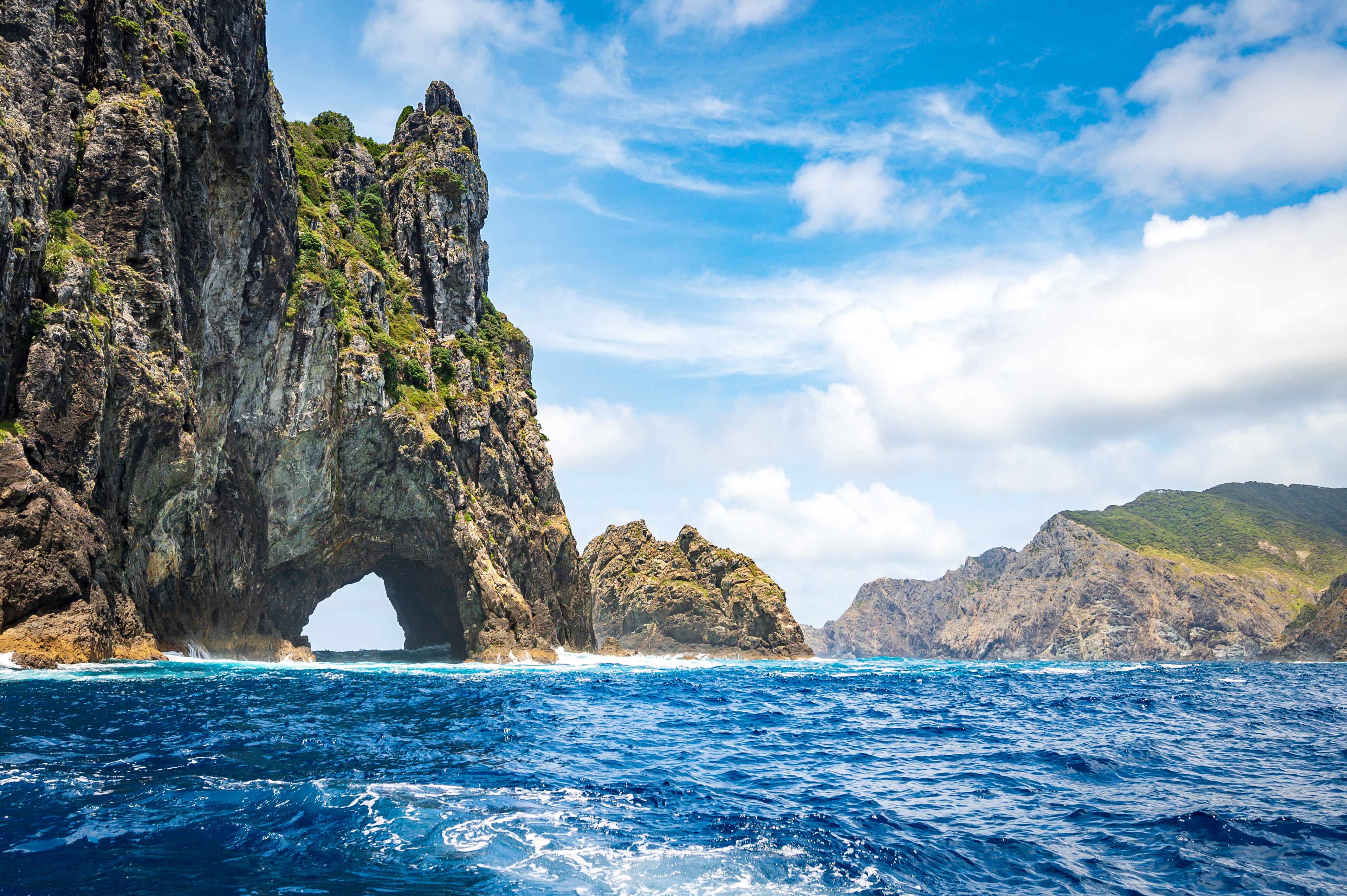 Imponerende klippeformation og naturlig stenabue ved Hole in the Rock i Bay of Islands, New Zealand