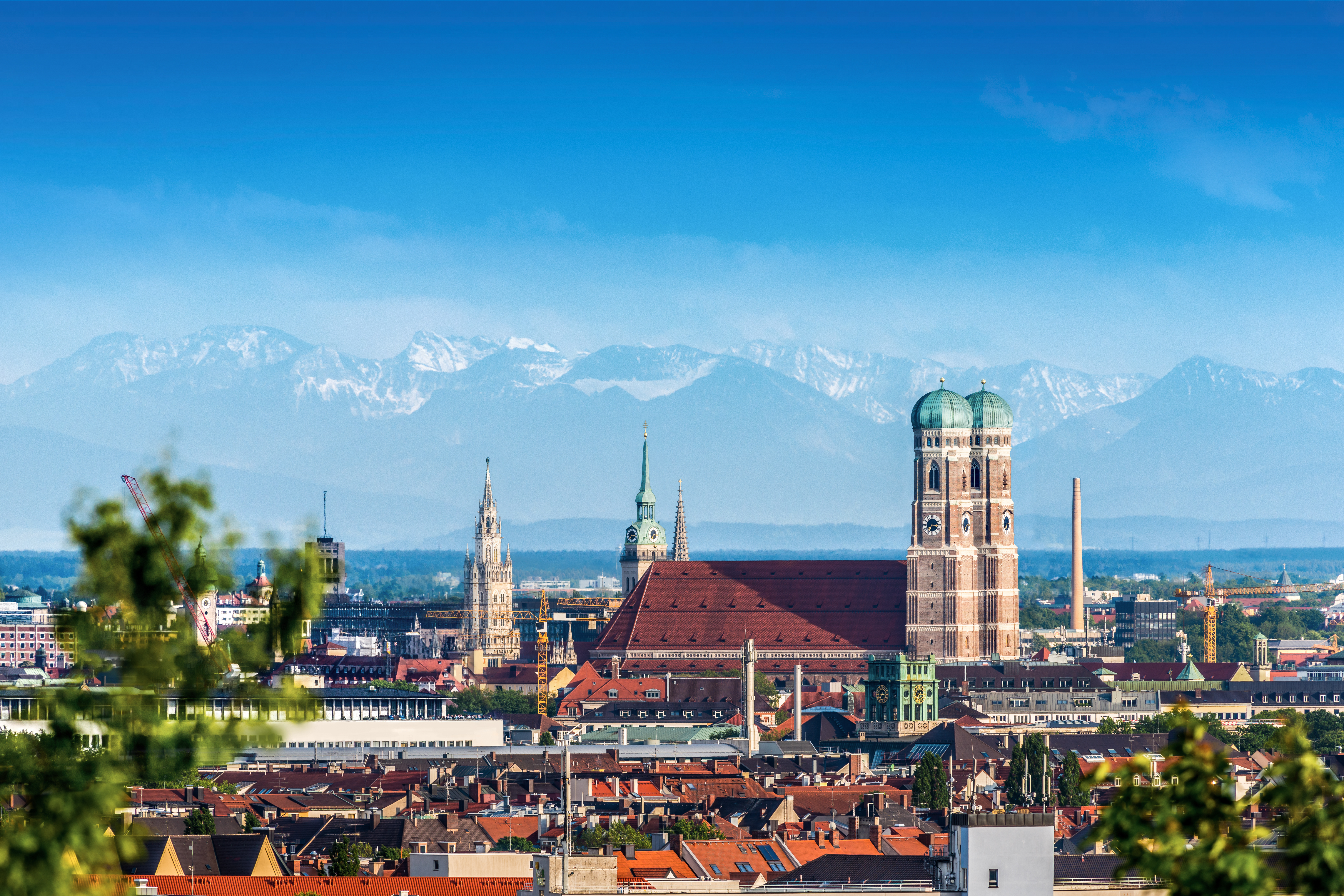Sommerudsigt over München i Bayern med historiske bygninger og alpine bjerge