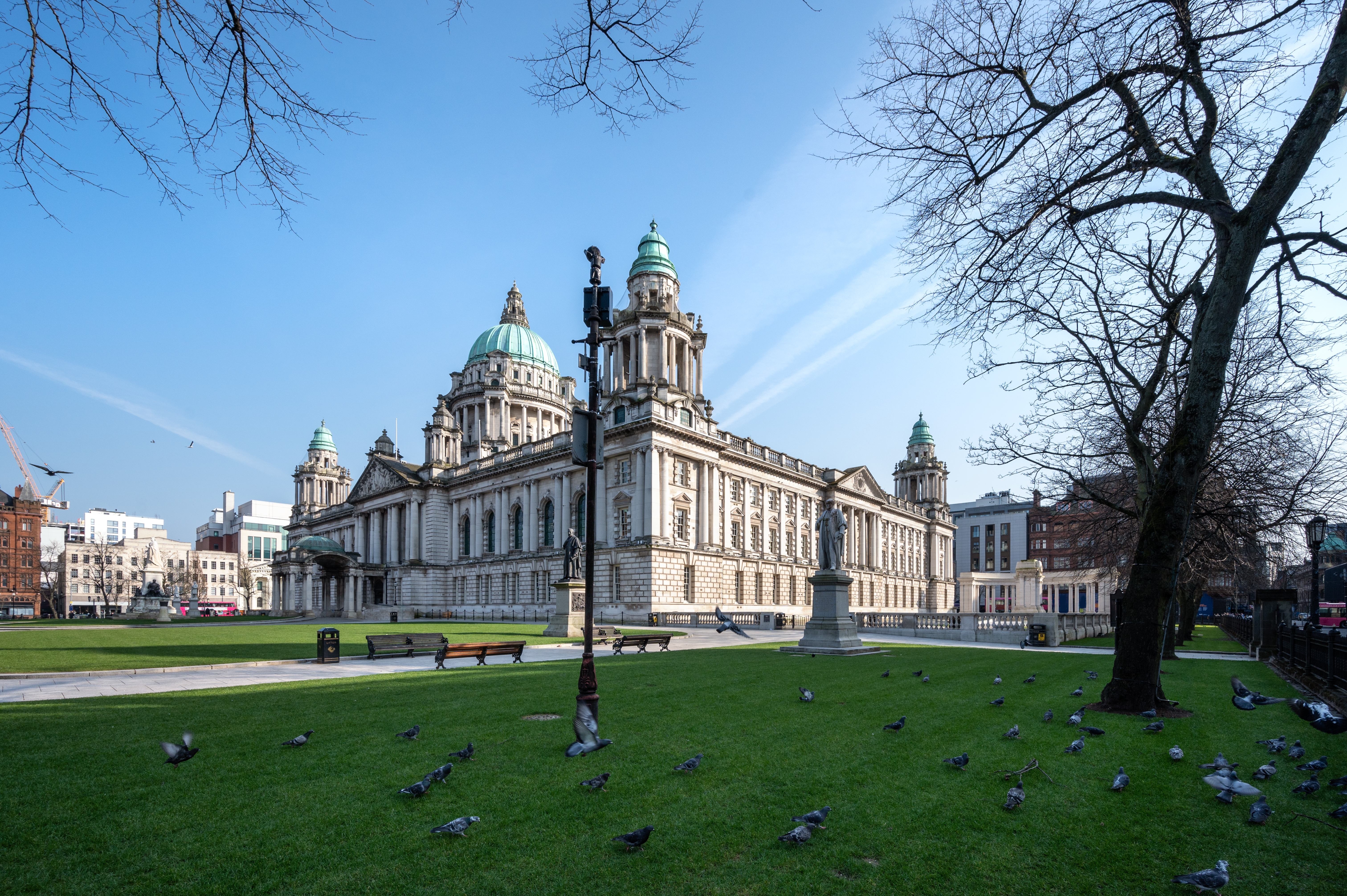 Belfast historiske rådhus omgivet af grøn park og træer i Irland