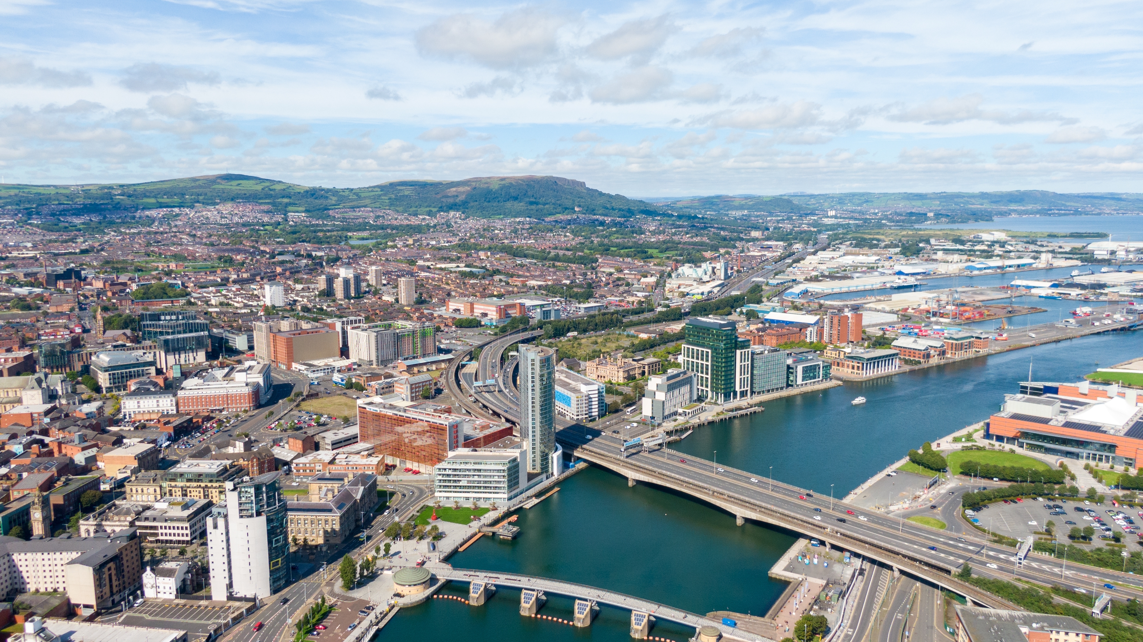 Luftfoto over Belfast med broer over River Lagan og det moderne bycenter i Nordirland