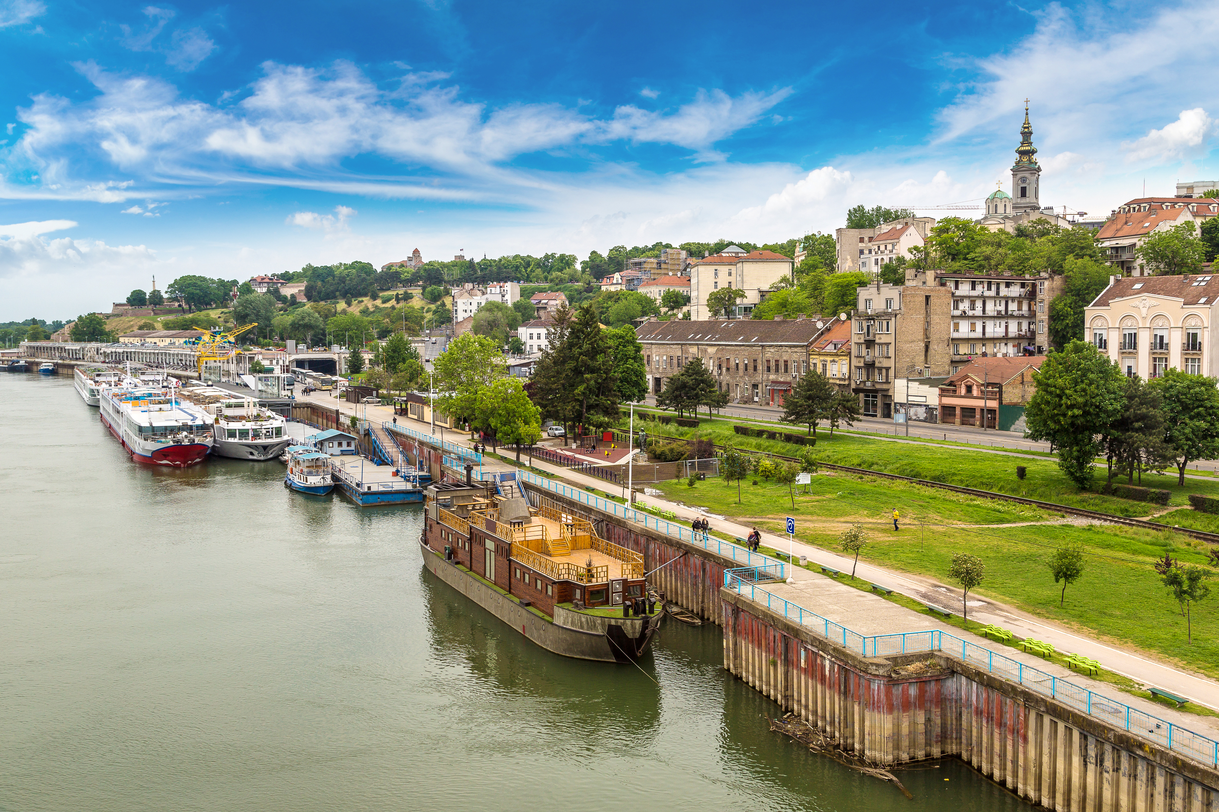 Belgrade flodfront med gamle bygninger og turistbaade ved Donau