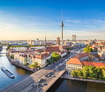 Smuk solnedgang over Berlin med TV-tårnet ved Alexanderplatz og Spree floden
