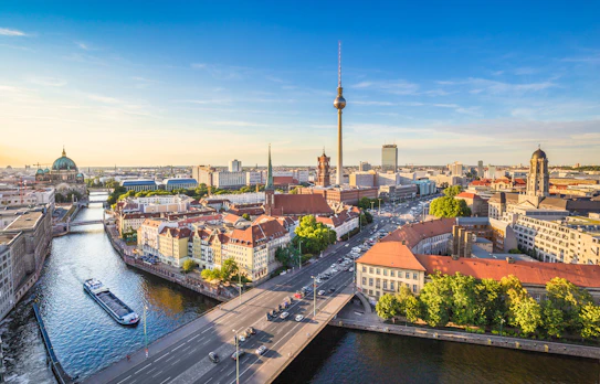 Smuk solnedgang over Berlin med TV-tårnet ved Alexanderplatz og Spree floden