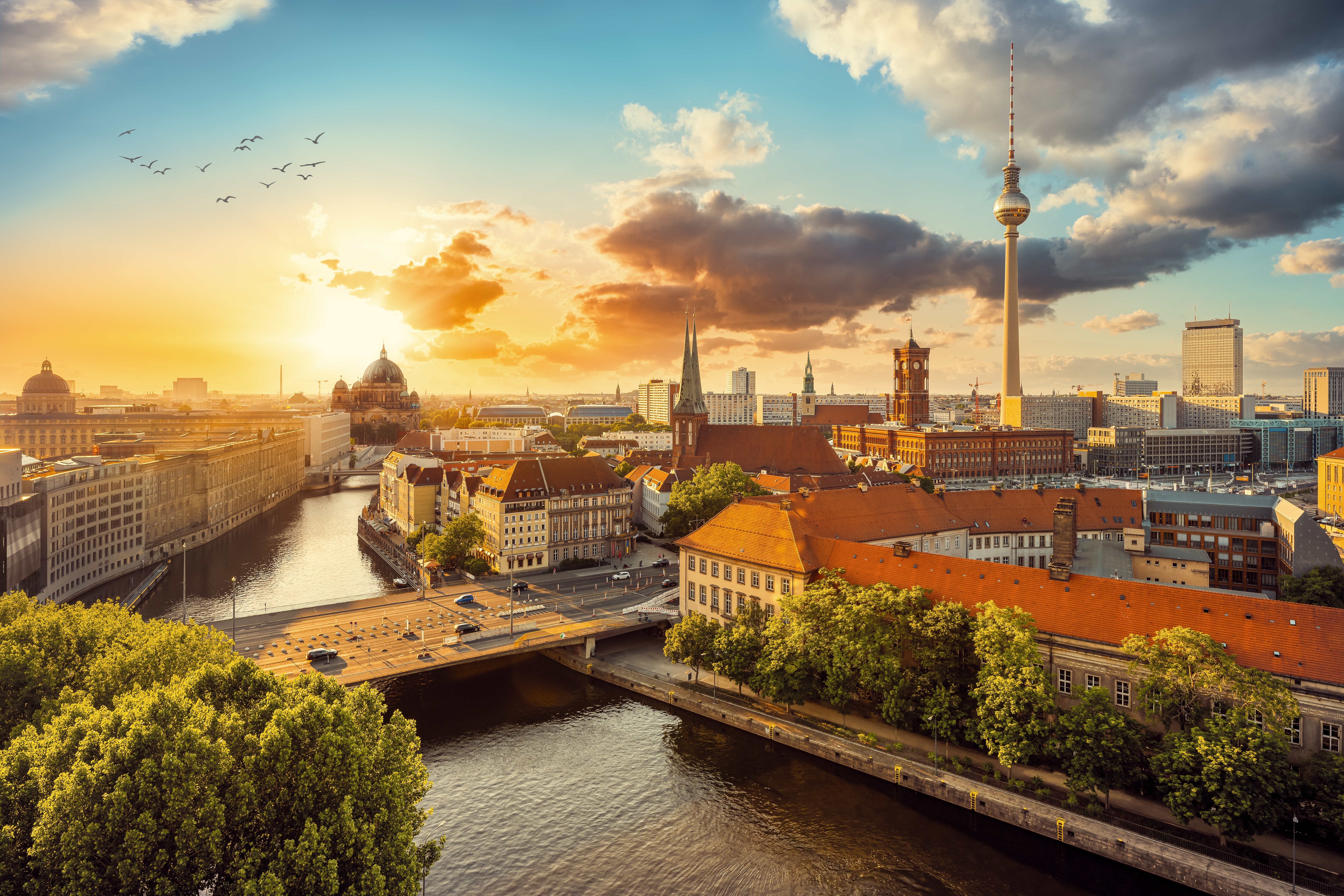 Gyldent aftenlys over Berlins skyline med TV-tårnet ved Alexanderplatz og den historiske Berlin Domkirke ved Spreefloden