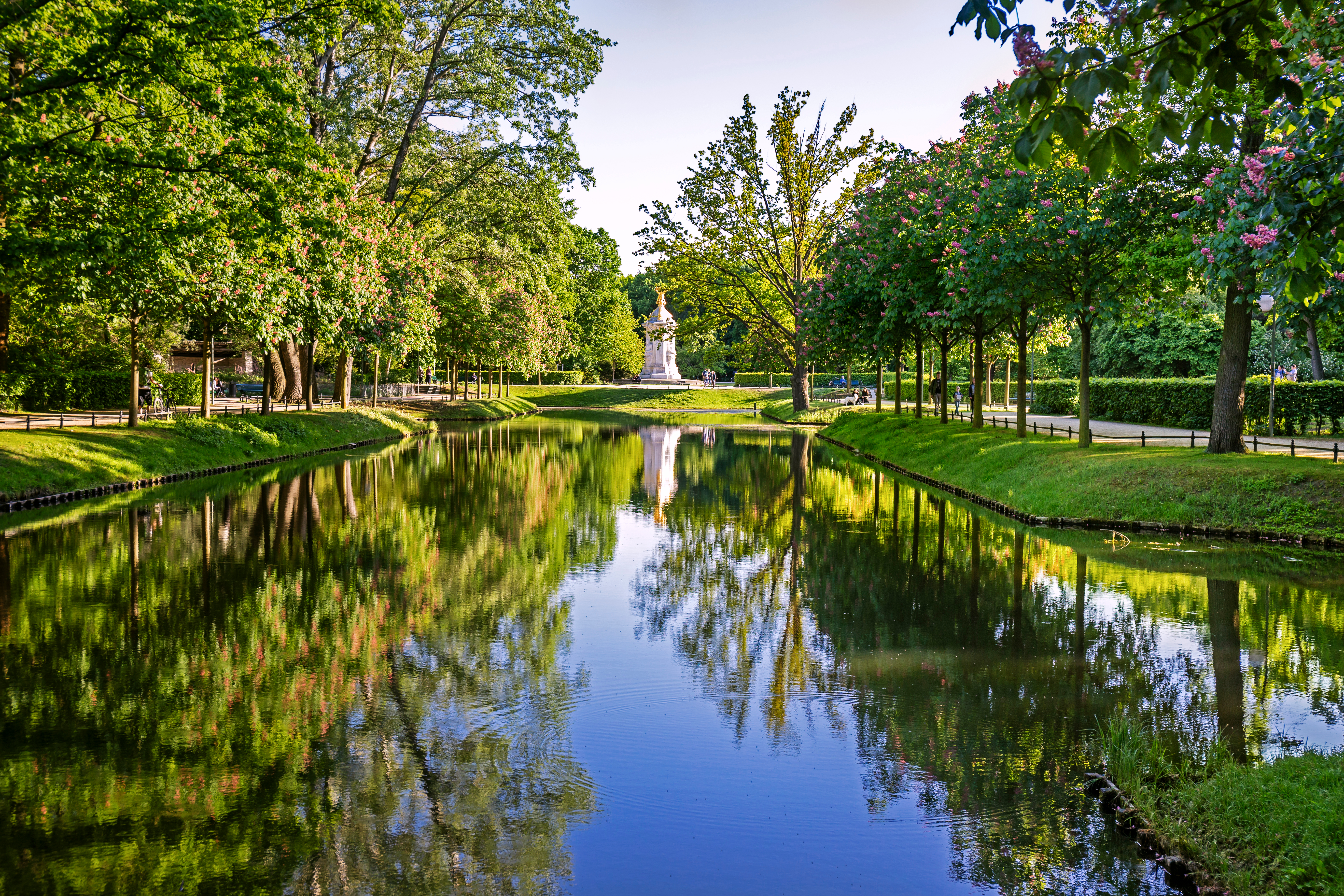 Berlin bypark med smuk vandspejling og forårsnatur under blå himmel