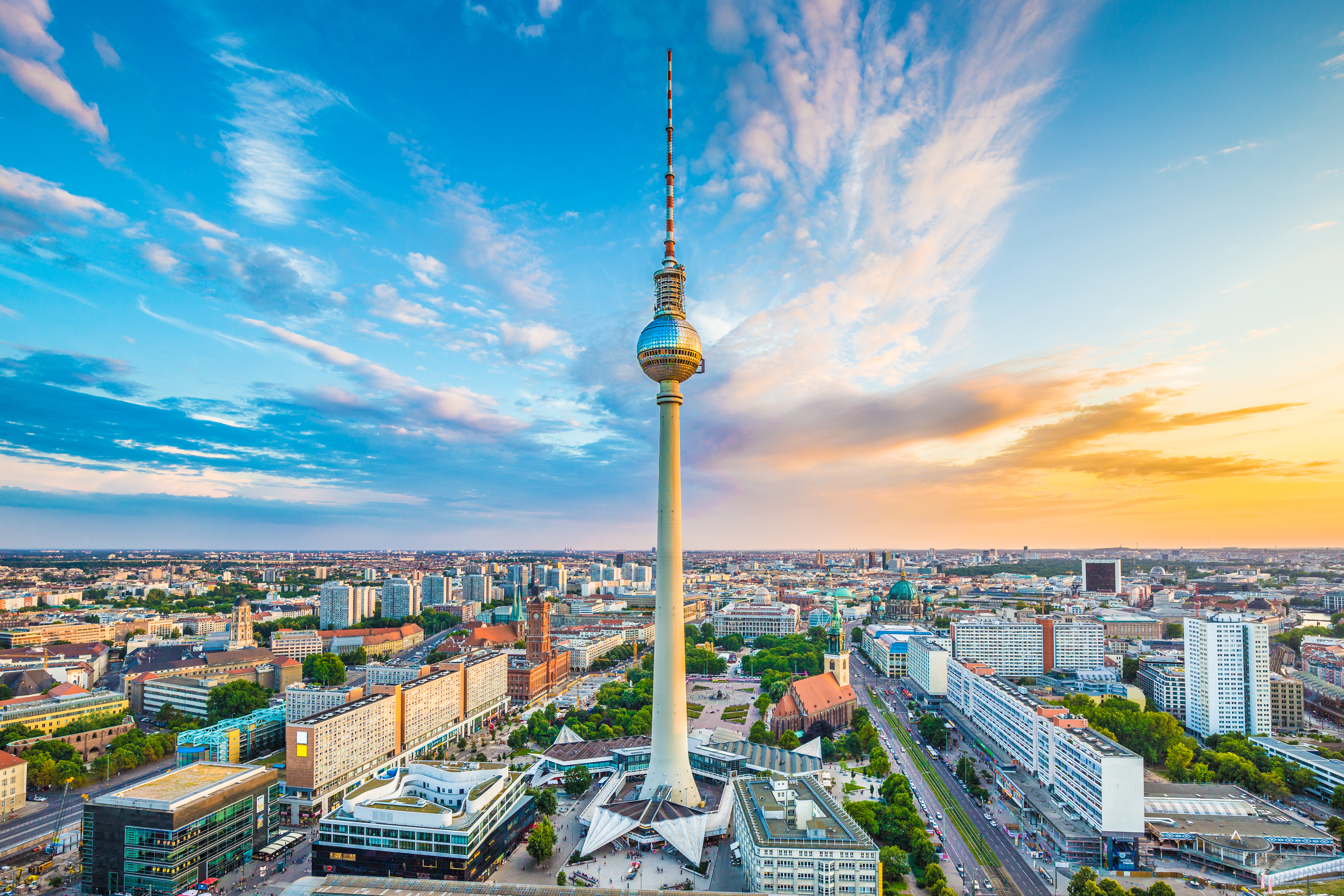 Berlin centrum med det ikoniske TV-tårn under en farverig solnedgang med flotte skyer