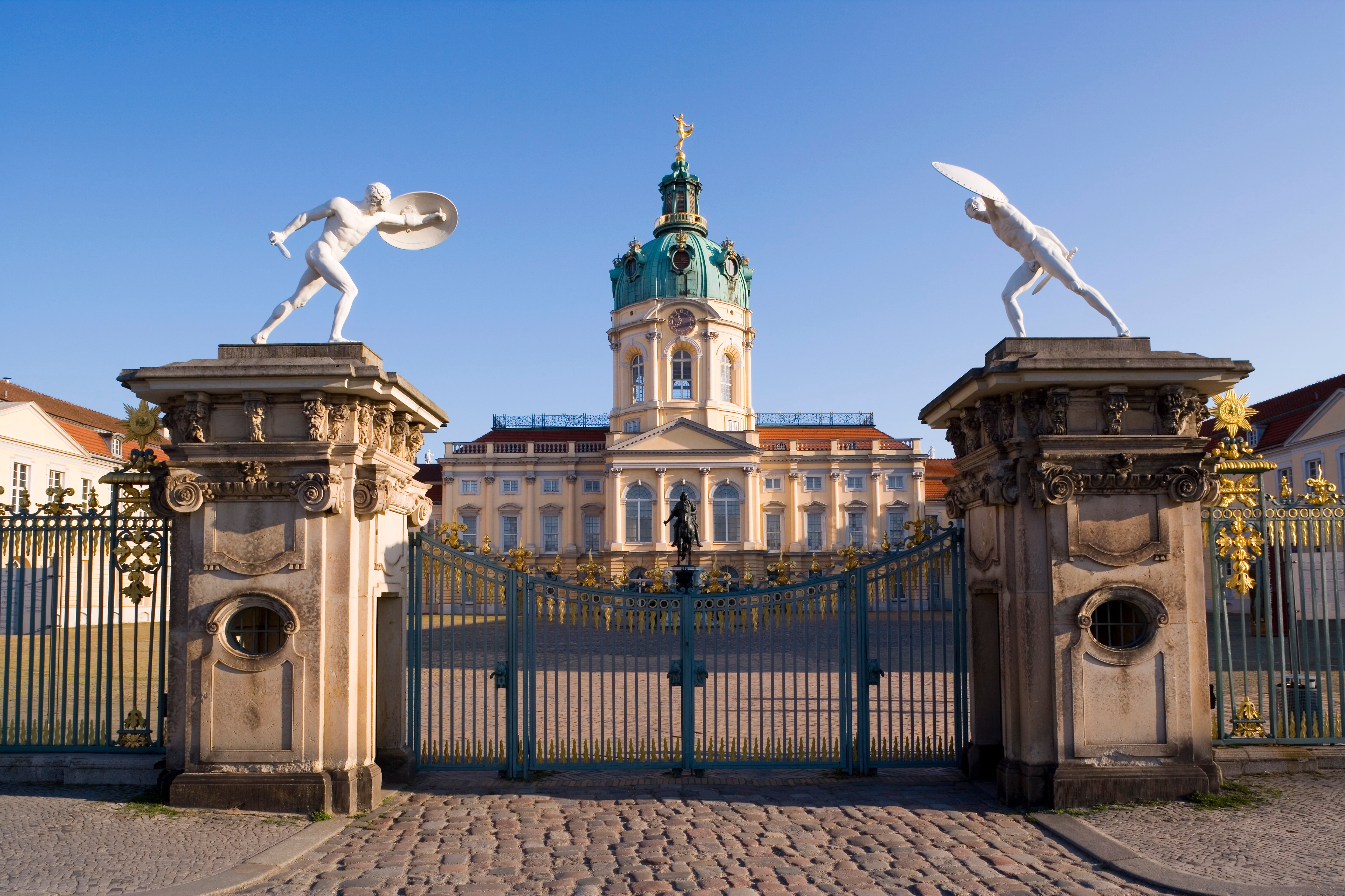 Storslået udsigt til Charlottenburg Slot i Berlin med karakteristisk grøn kuppel, barokarkitektur og forgyldt indgangsport