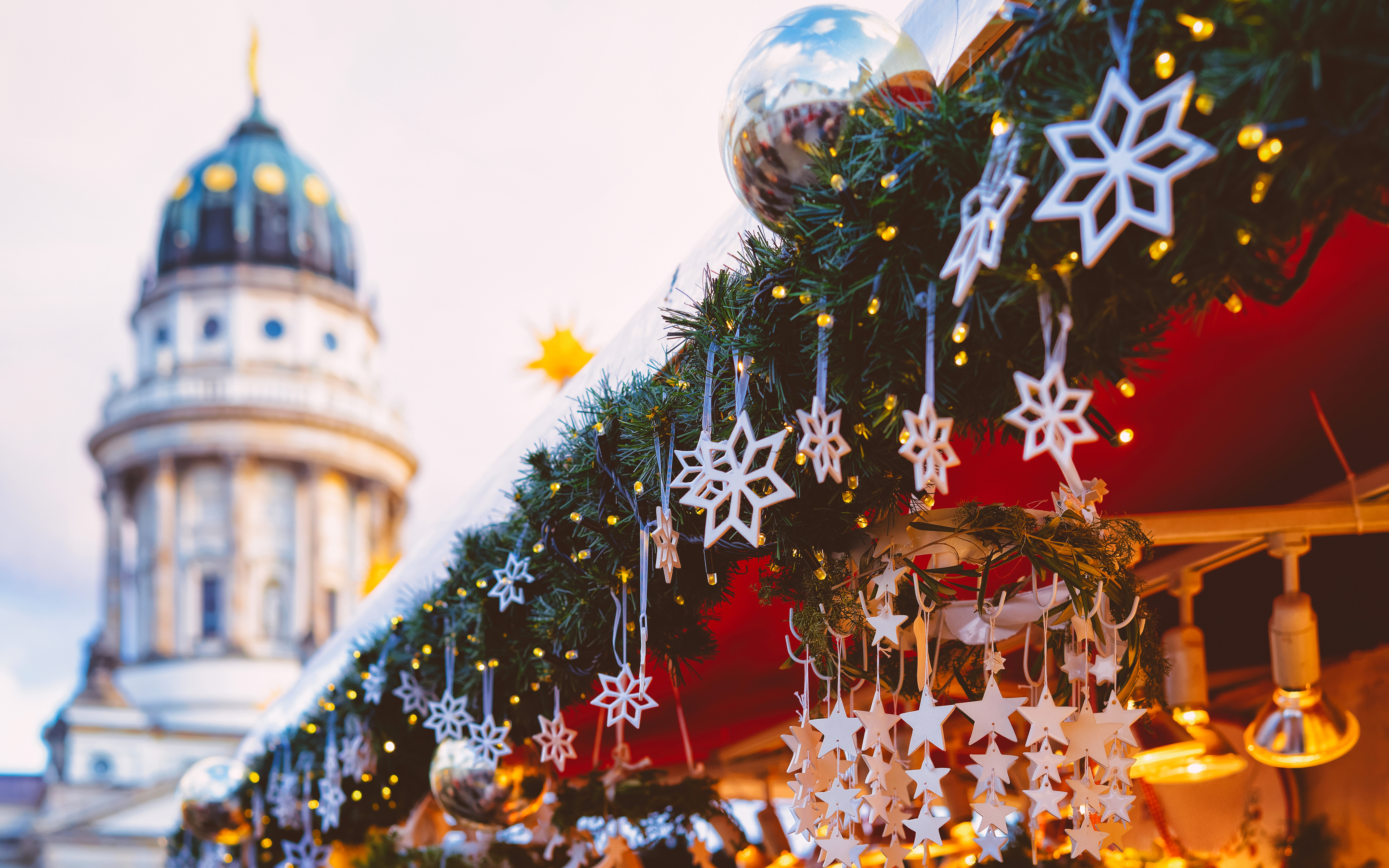 Hyggelige julemarkedsstande med lys og katedral i baggrunden, Berlin