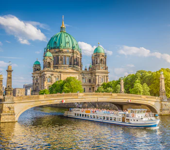 Berlin Domkirke med grønne kupler og turistbåd i det historiske centrum