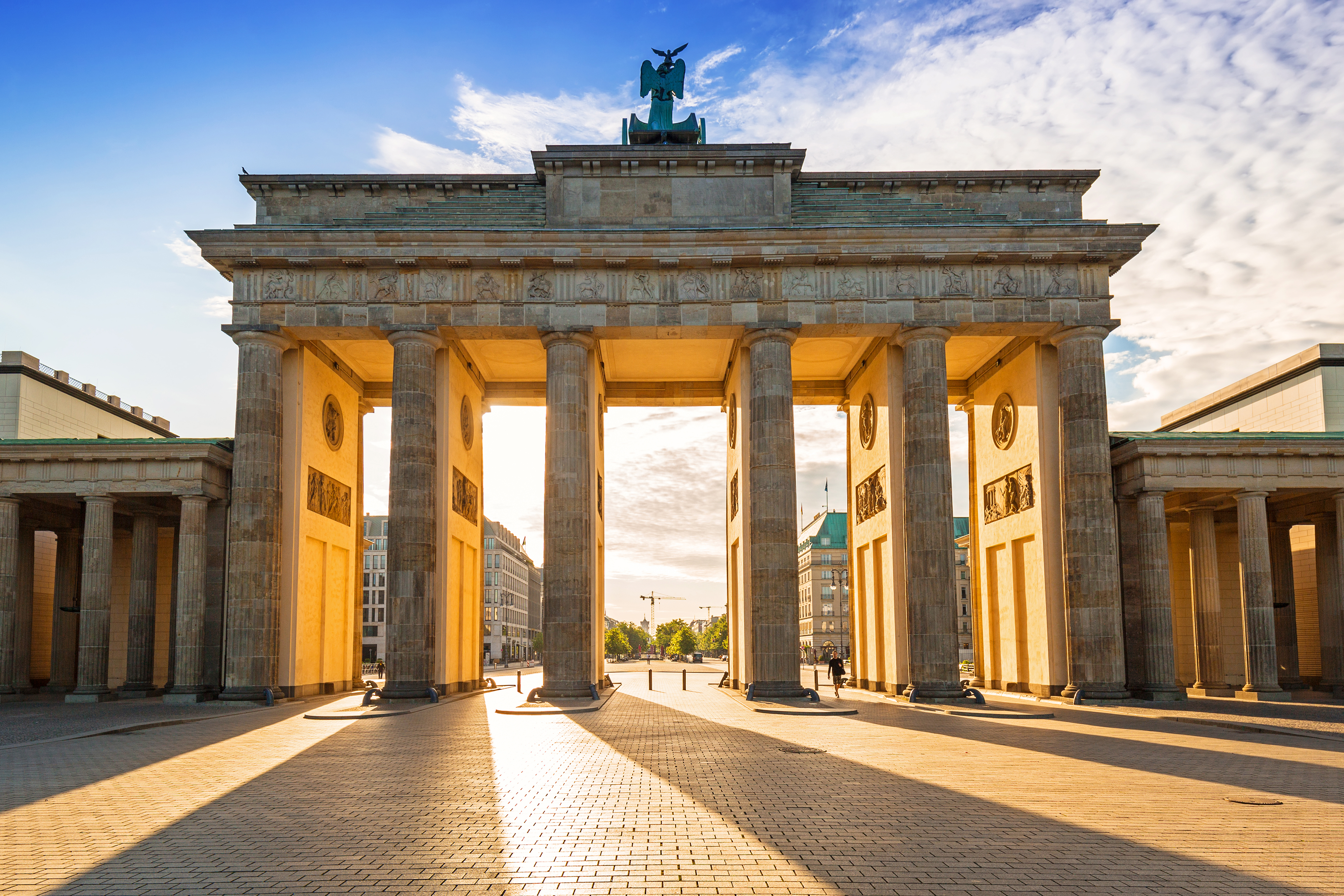 Berlins ikoniske Brandenburg Tor belyst af solnedgangens varme lys