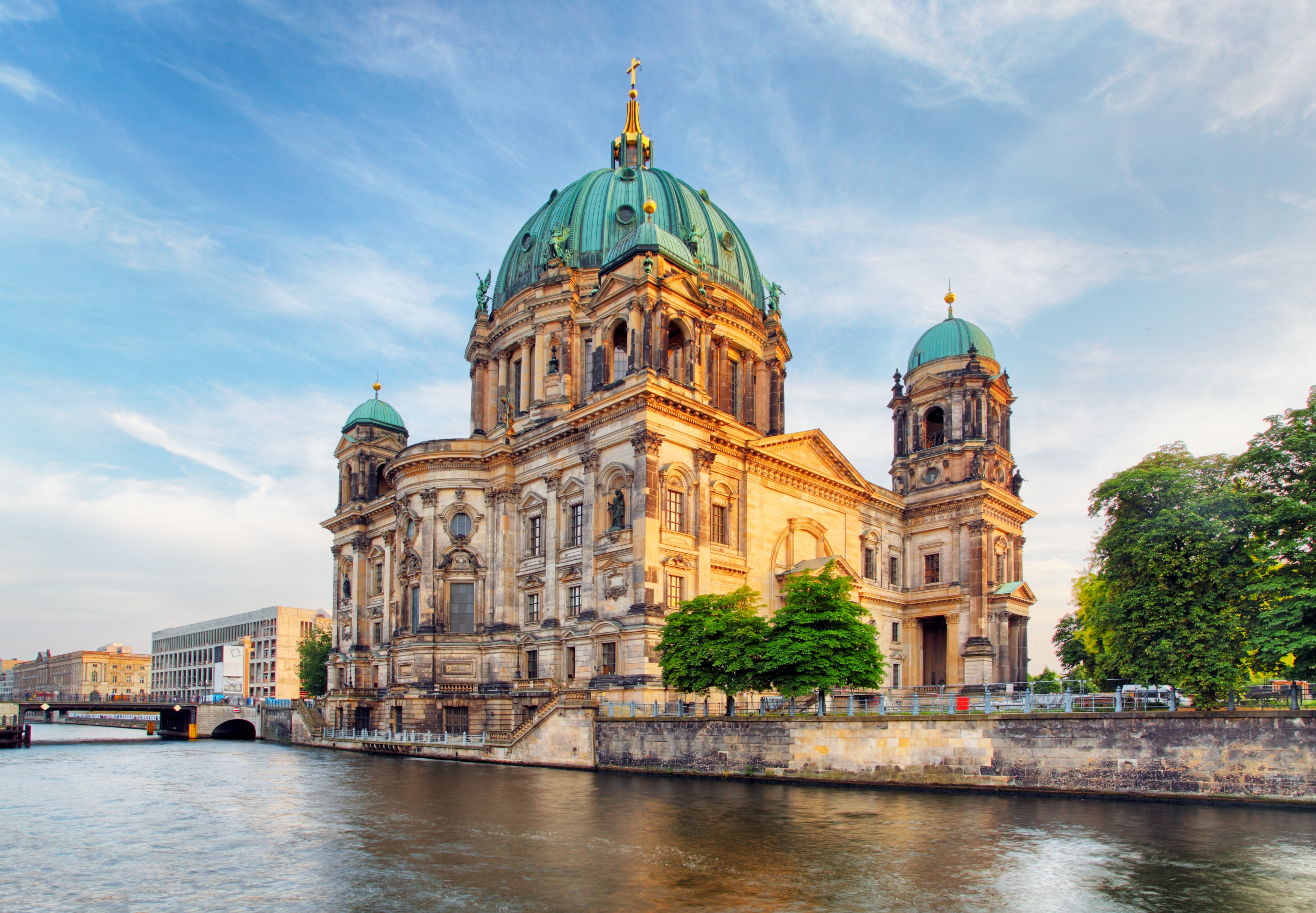Berliner Dom med karakteristiske grønne kupler ved Spree-floden om aftenen