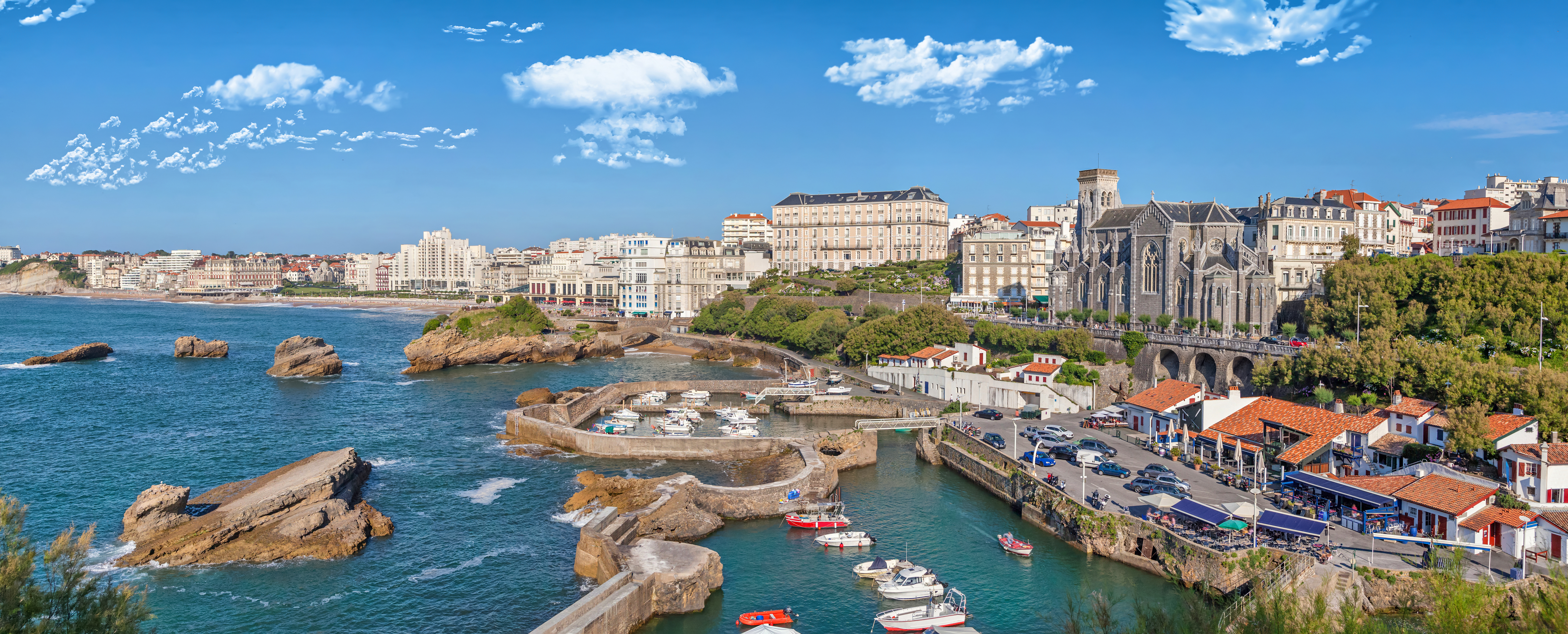 Panoramabillede af Biarritz med den charmerende havn, klippekysten og den smukke kirke Saint-Eugénie ved den baskiske kyst i det sydvestlige Frankrig