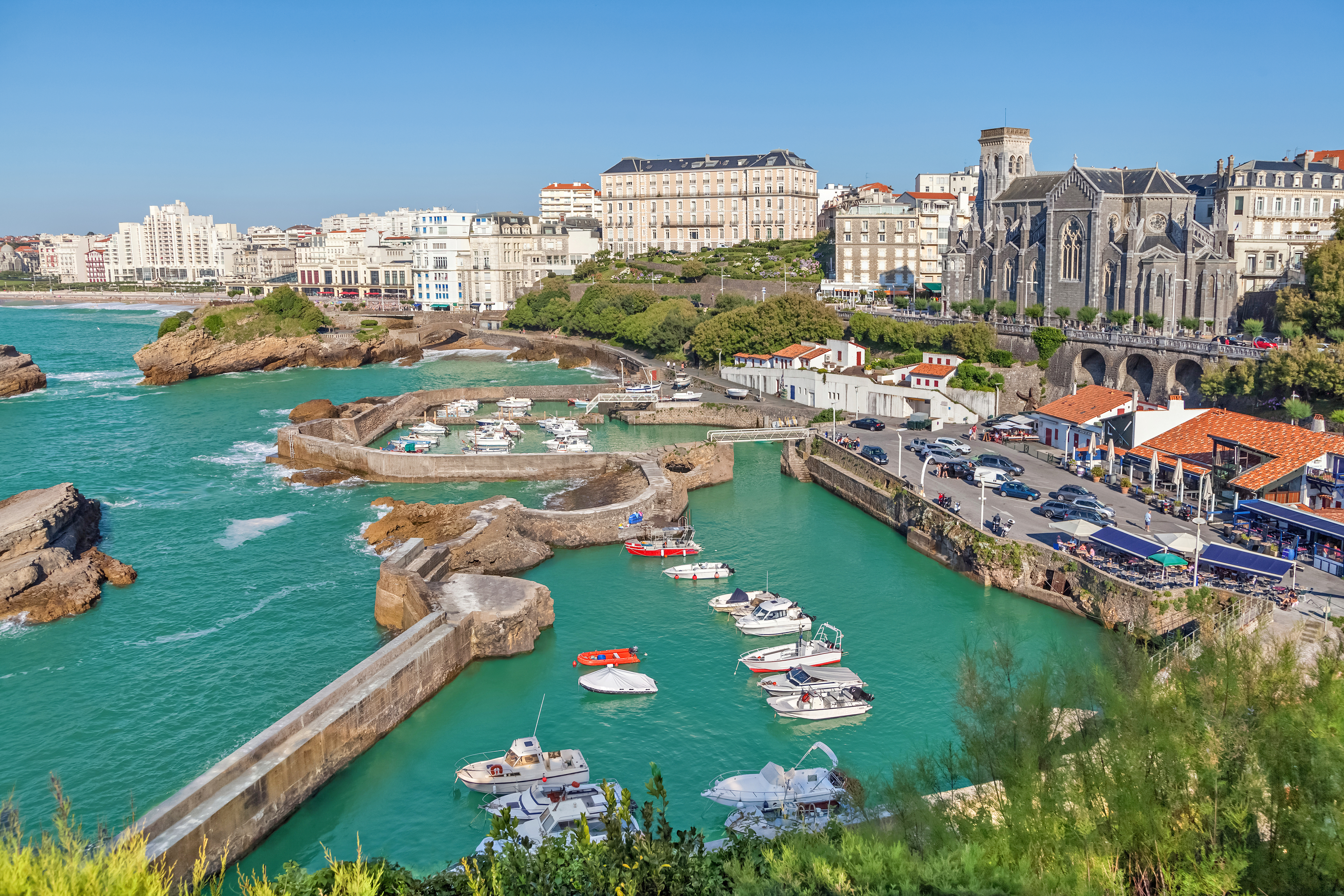 Fantastisk havneudsigt i Biarritz med turkise farvande, lystbåde og majestætisk kirke ved atlanterhavet