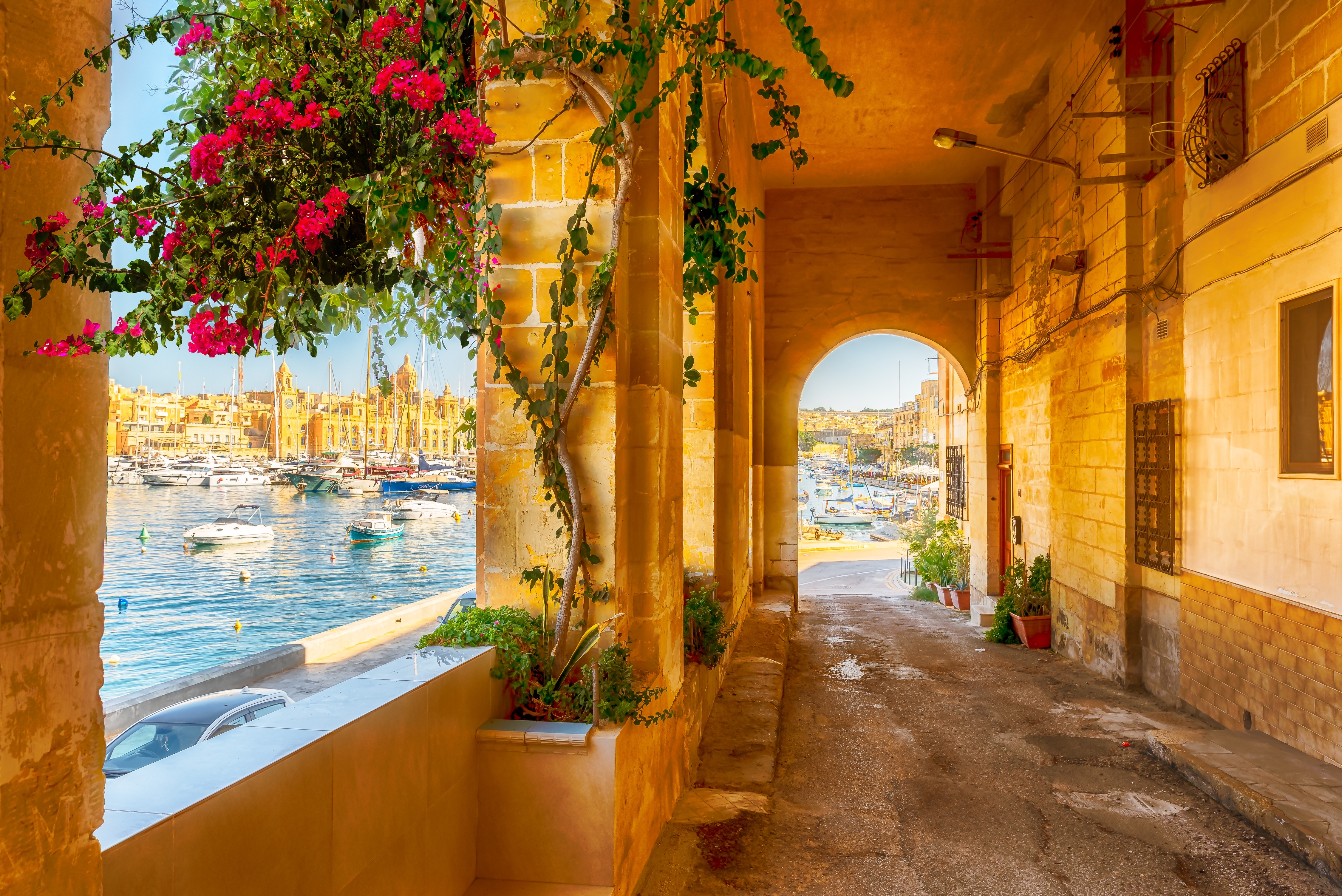 Maleriske arkader i Birgu med blomsterpragt og udsigt over den historiske havn