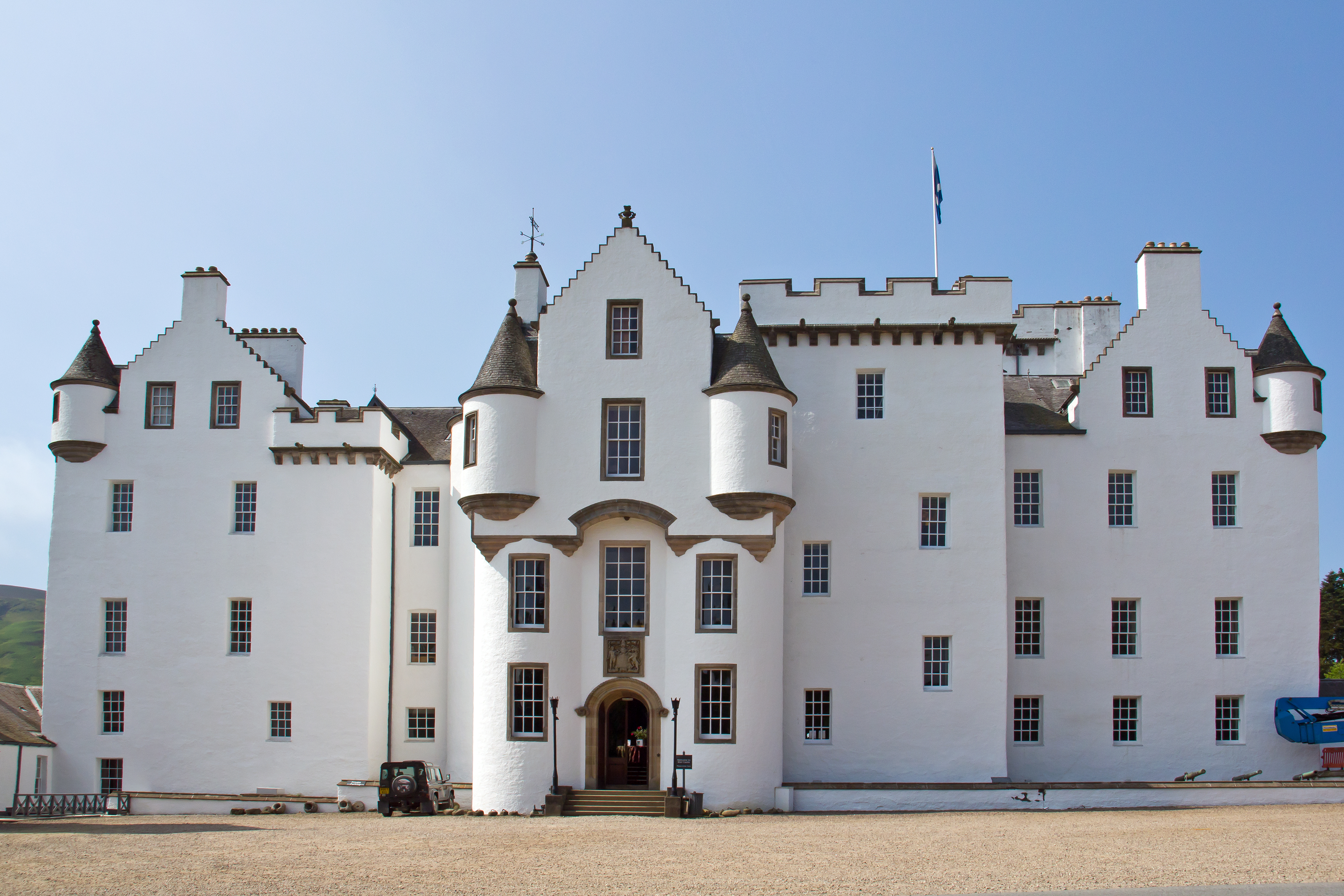 Besøg Blair Castle i Blair Atholl, Skotland – et smukt hvidt slot med historiske tårne og en charmerende indgang på en solskinsdag