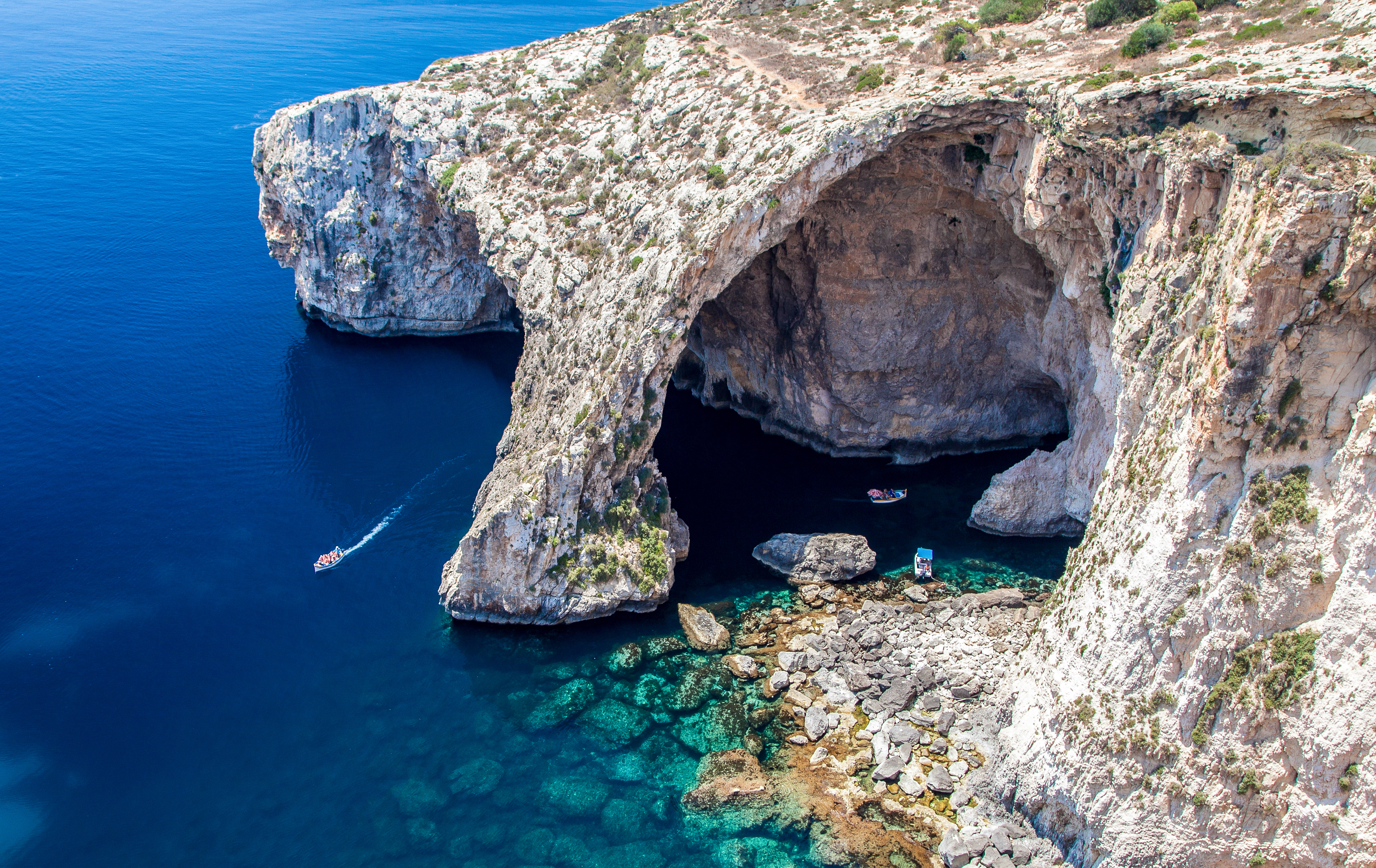 Maltas ikoniske Blue Grotto med sine majestætiske kalkstensklipper og det intenst blå Middelhav, der skaber en fascinerende naturlig havgrotte ved kysten