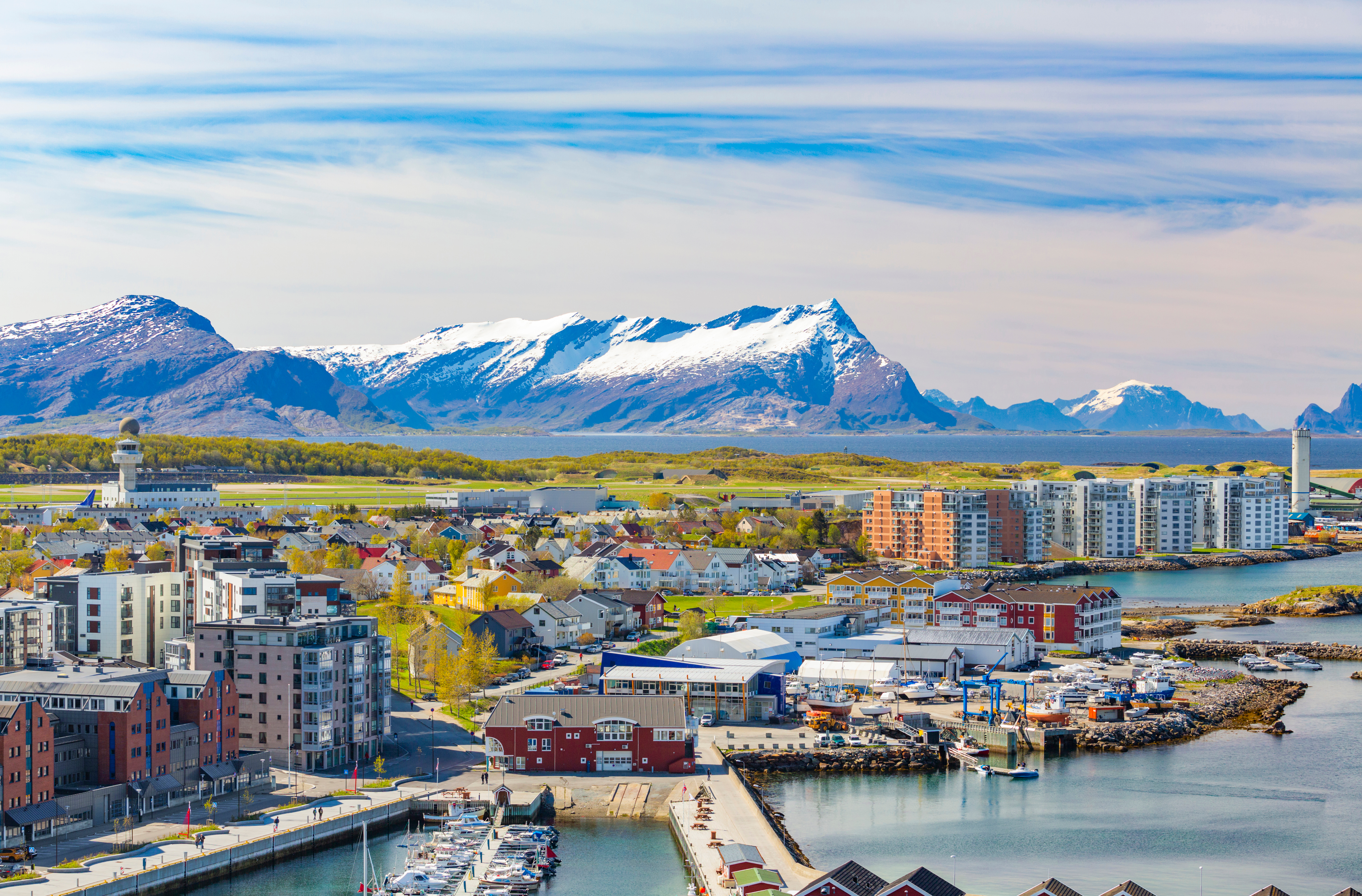 Fascinerende luftperspektiv over Bodø i Nordnorge, hvor den moderne by breder sig langs kysten med fjorde, havneområder og majestætiske bjerge der rejser sig i horisonten