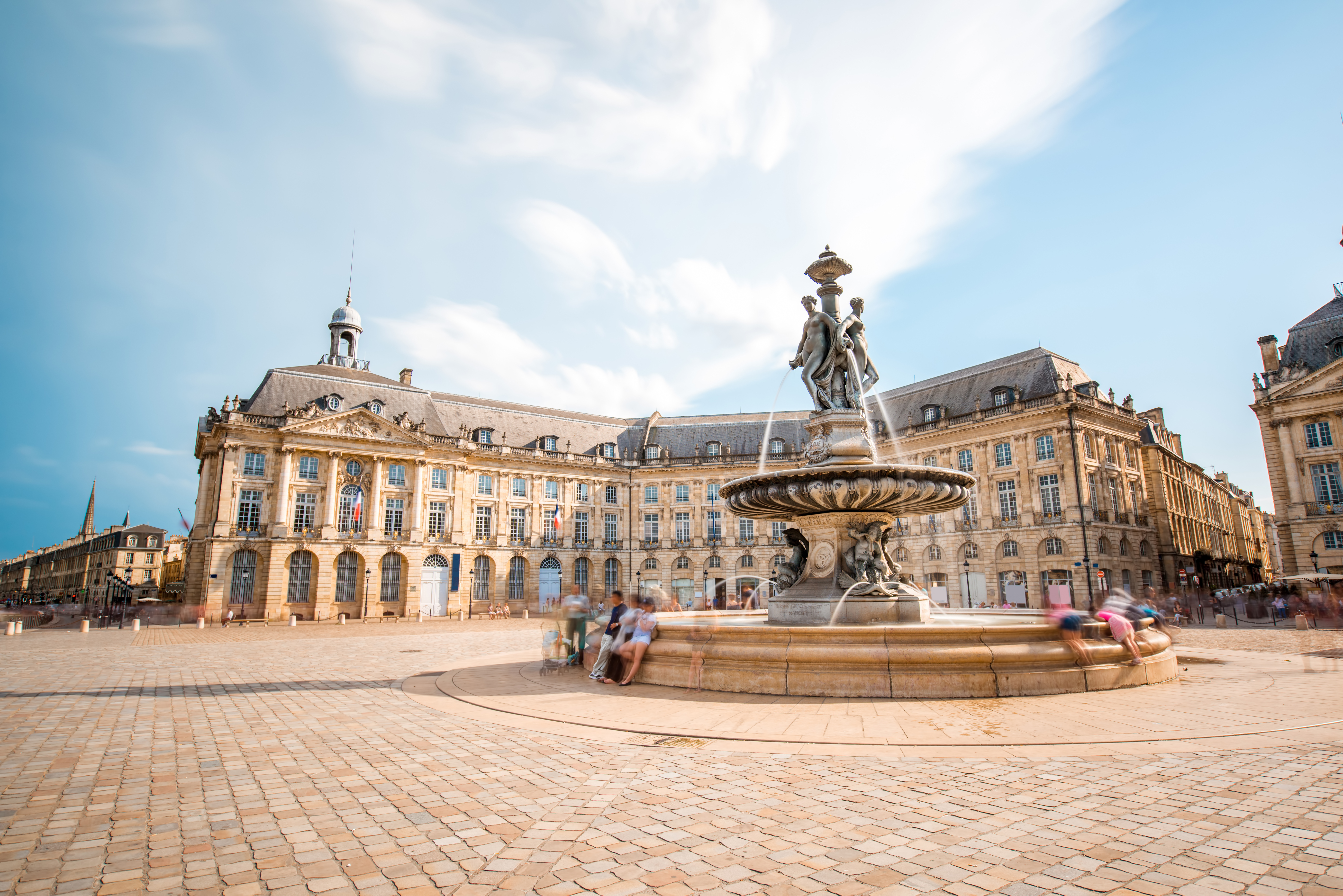 Det ikoniske torv Place de la Bourse i Bordeaux, Frankrig, med det elegante springvand De Tre Gracer og klassiske bygninger