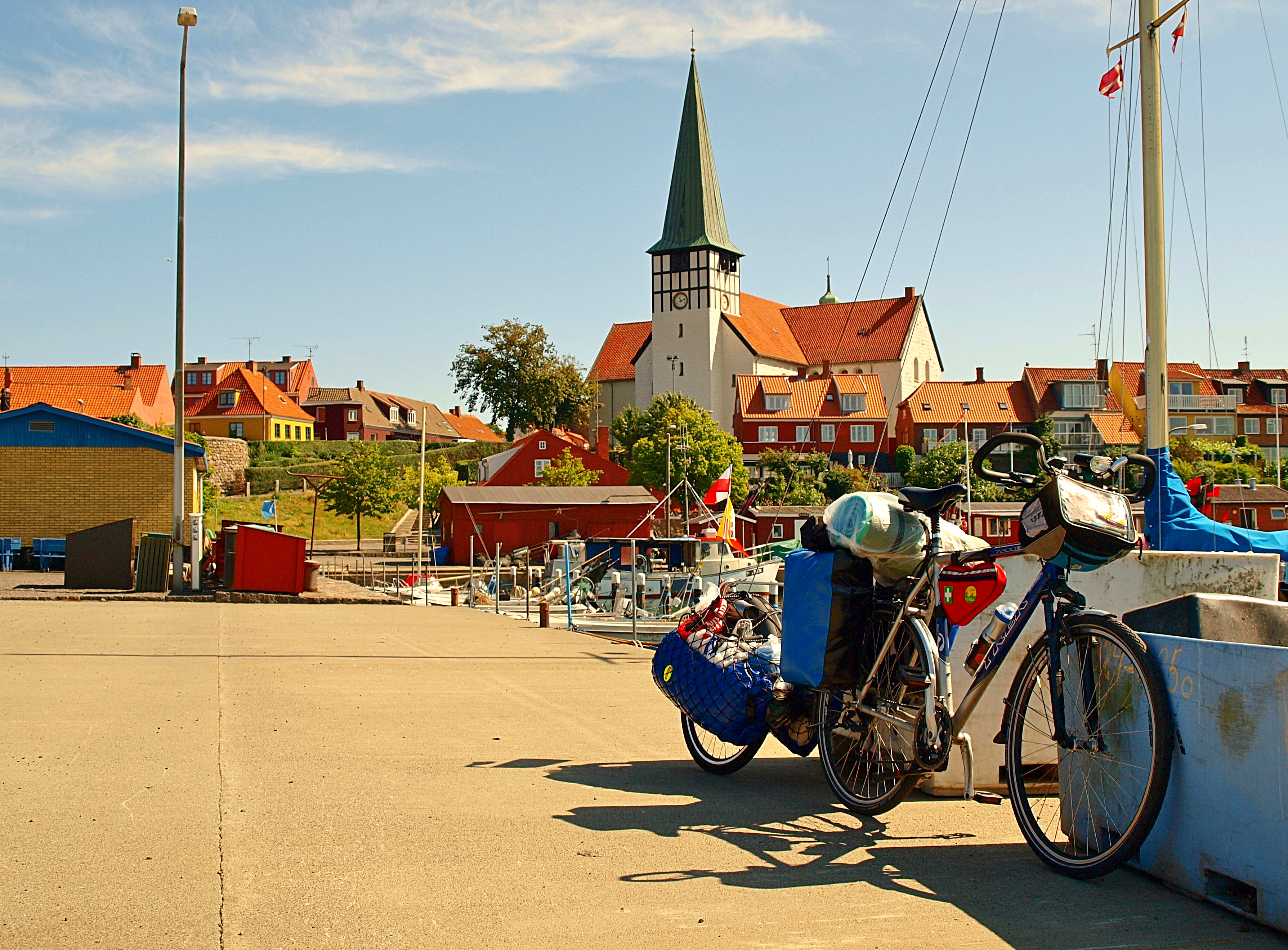 Sommerferie på Bornholm med cykel ved Rønne havn og den smukke kirke med grønt spir