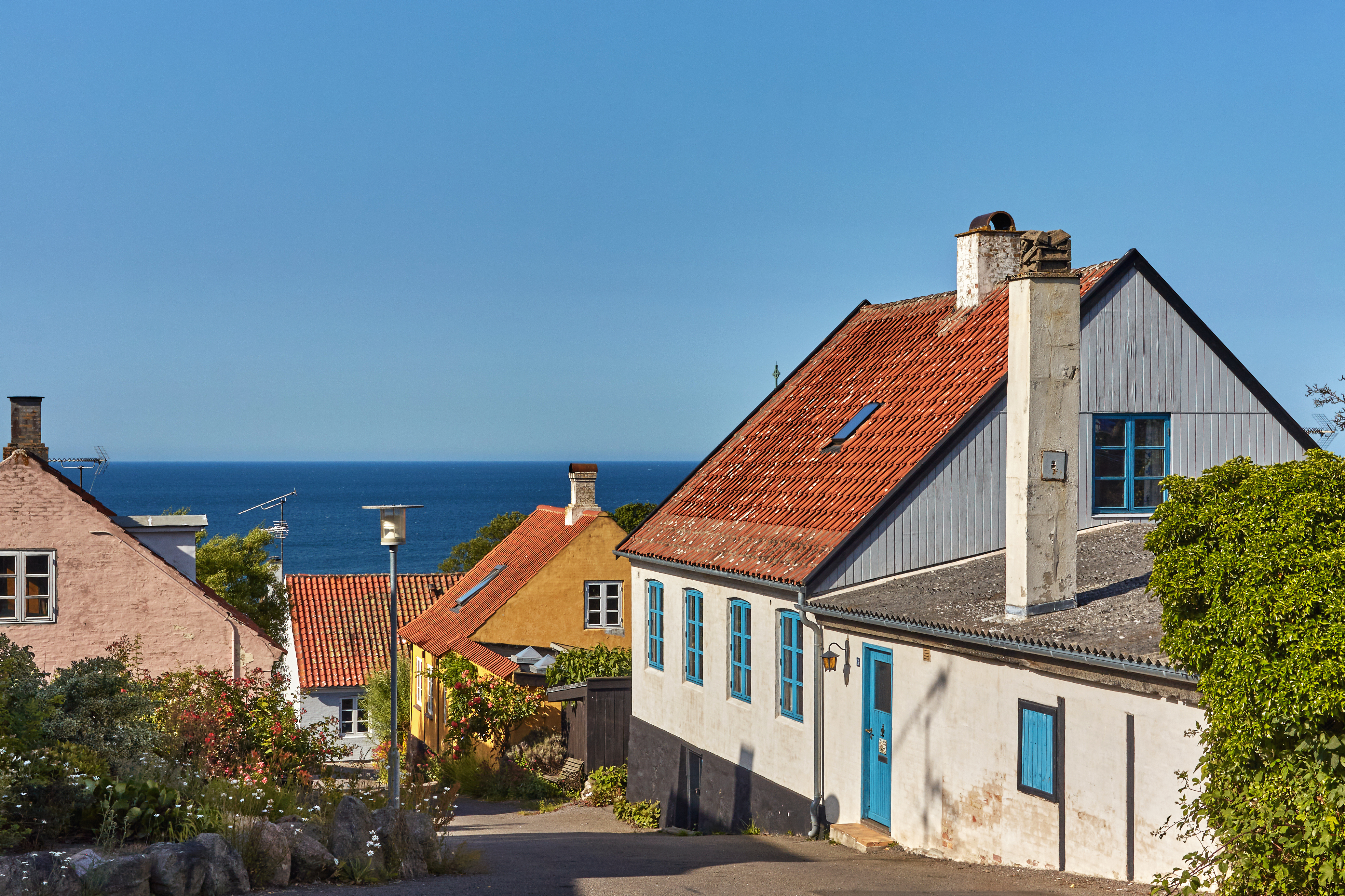 Smukke traditionelle danske huse på bakke med panoramaudsigt over Østersøen i Gudhjem