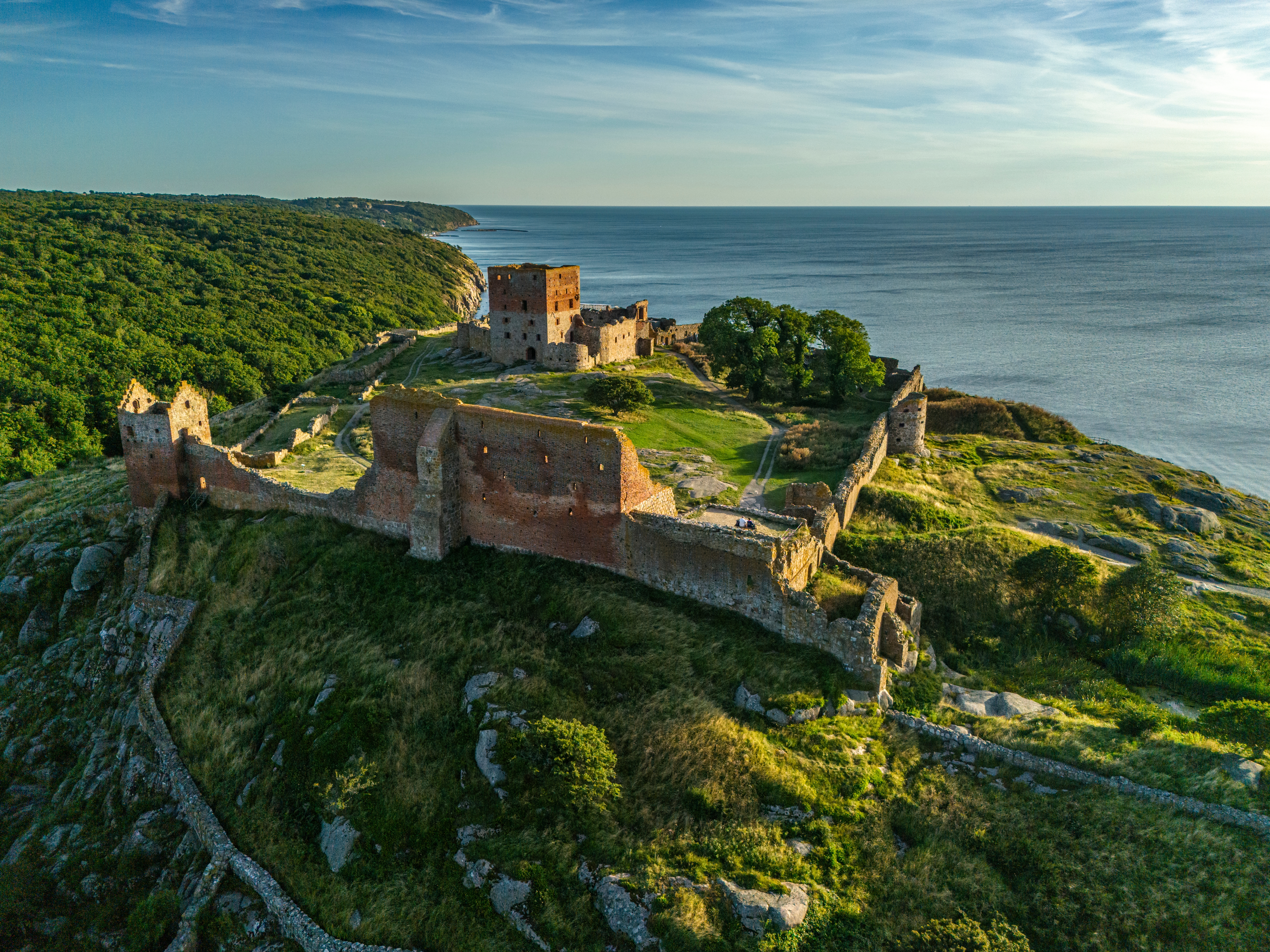 Smuk luftfoto af Hammershus middelalderborg på Bornholm med grønne klippeskrænter ud mod Østersøen