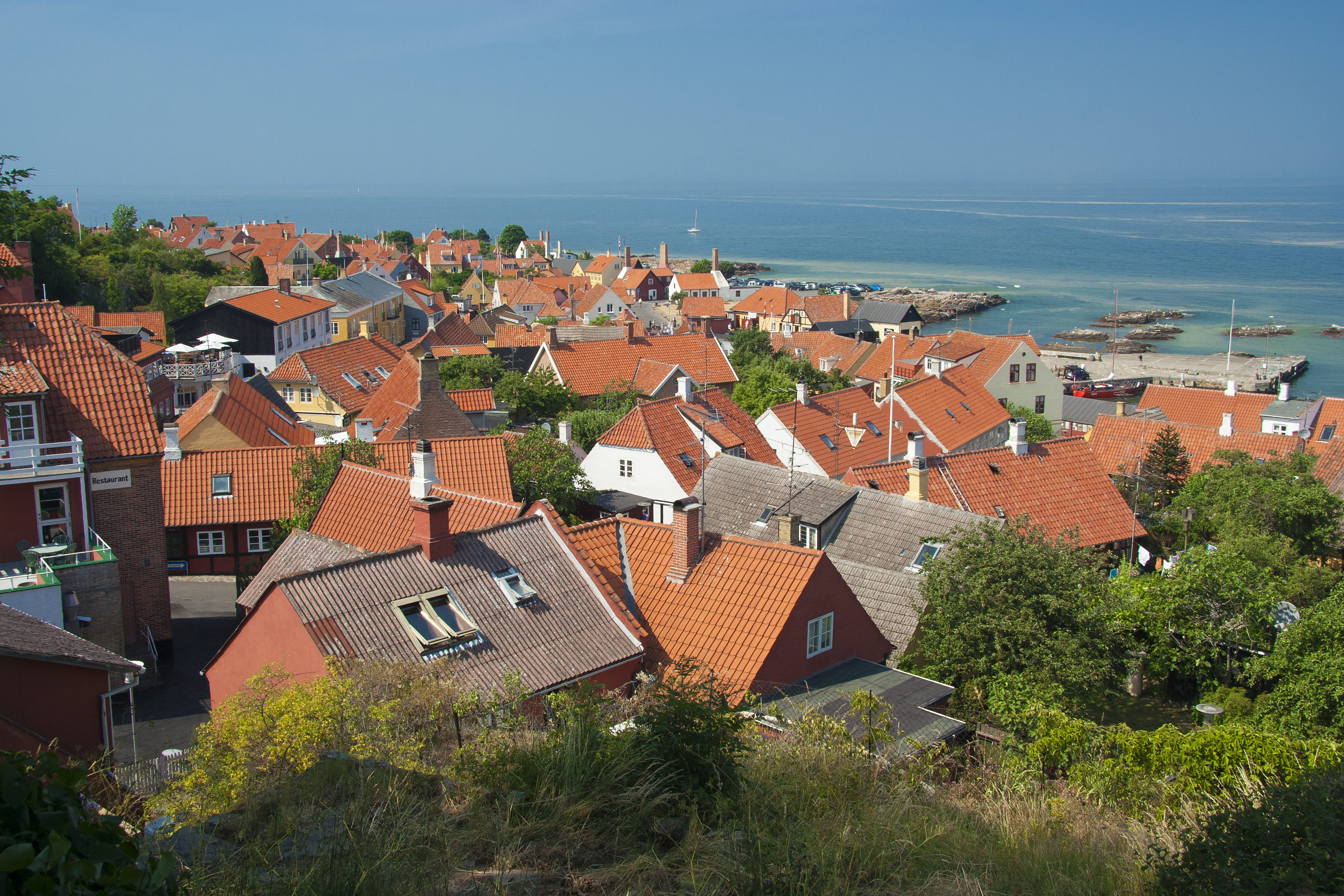 Smuk havneby på Bornholm med røde tegltage ved Østersøen