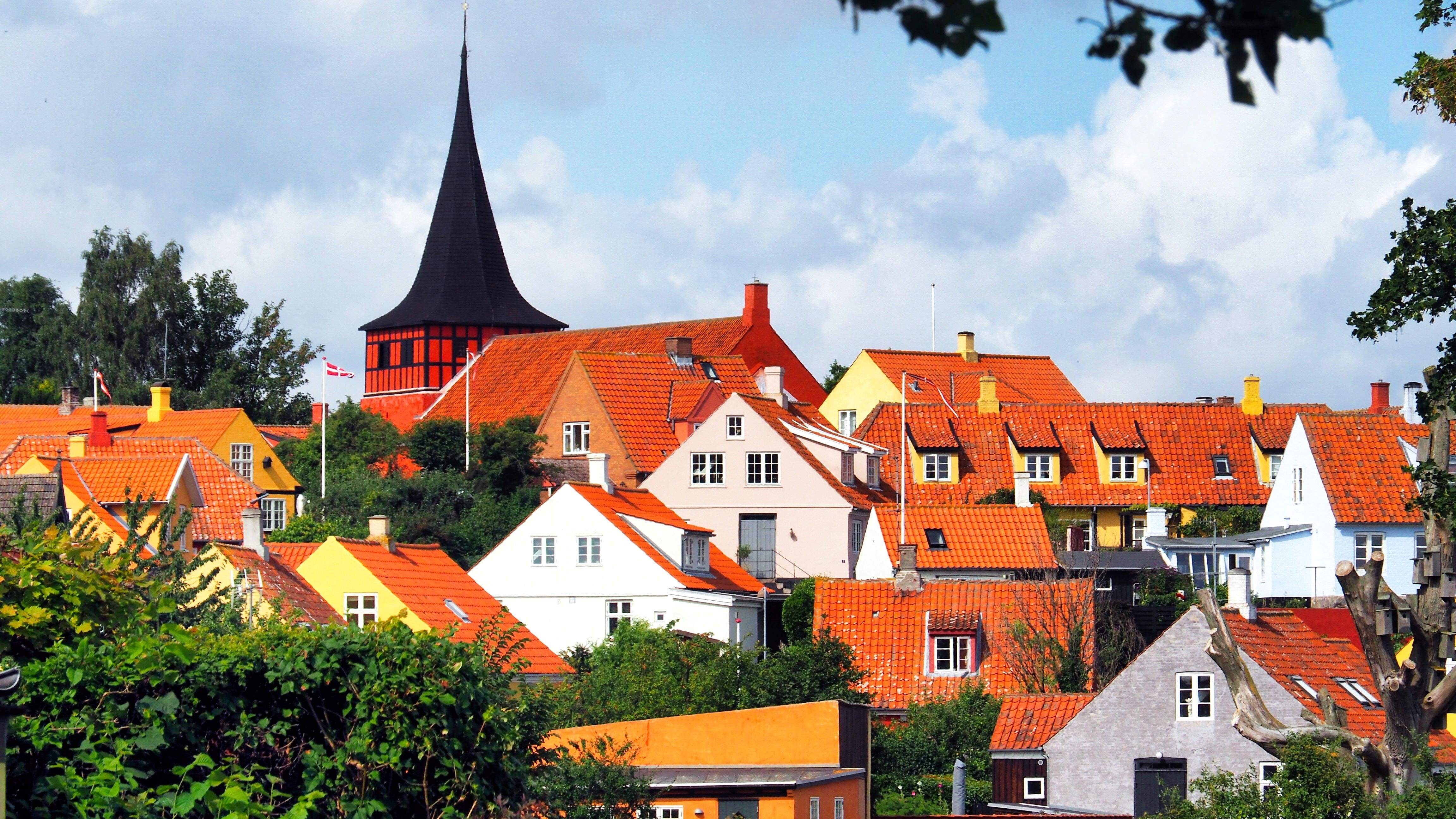 Smuk udsigt over den historiske by Svaneke på Bornholm med karakteristiske røde tegltage og sort kirkespir