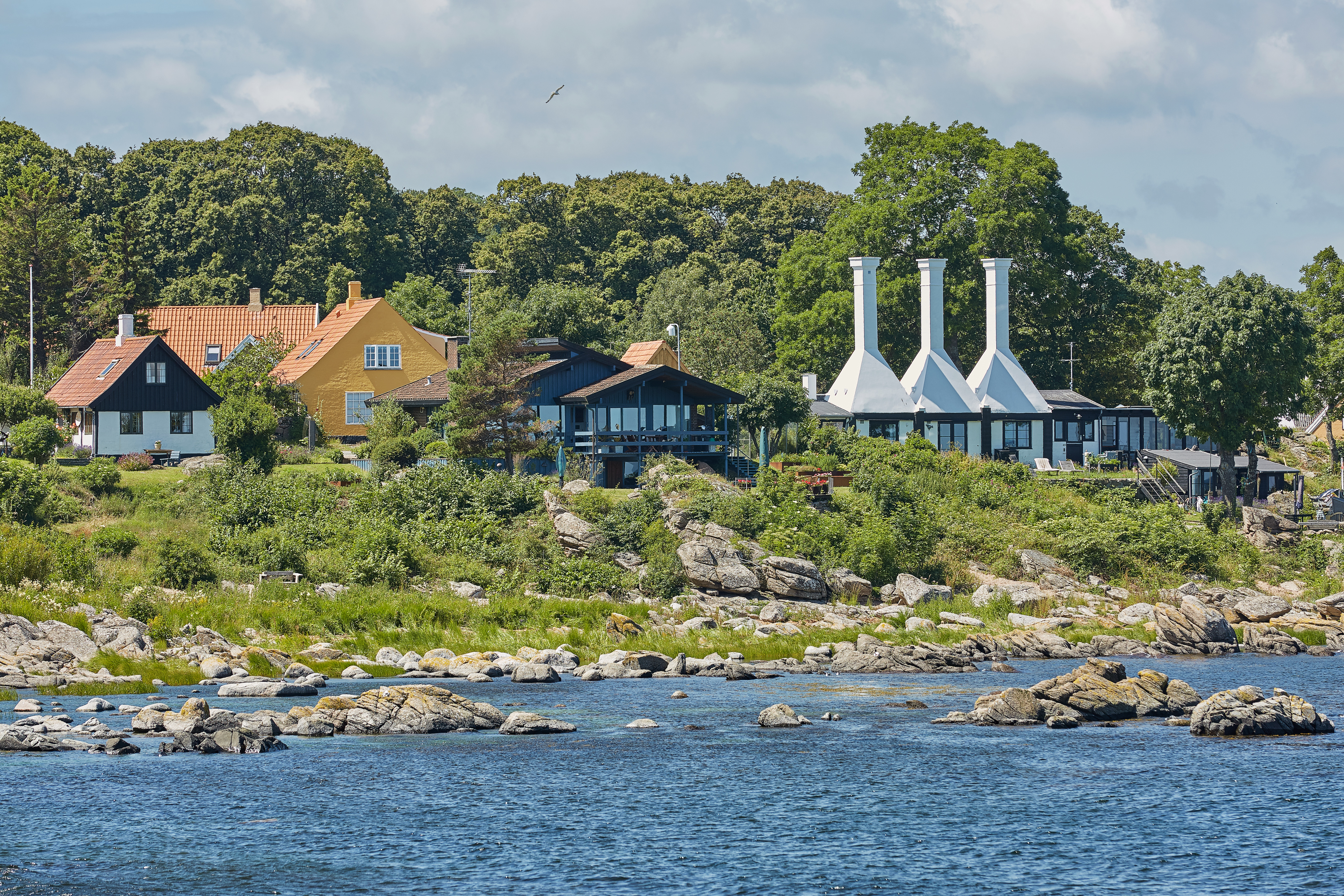 De maleriske røgerier med deres unikke tage og skorstene i den idylliske by Svaneke på Bornholm, hvor den ældgamle tradition for røgning af lokale fisk skaber nogle af Danmarks mest eftertragtede kulinariske specialiteter