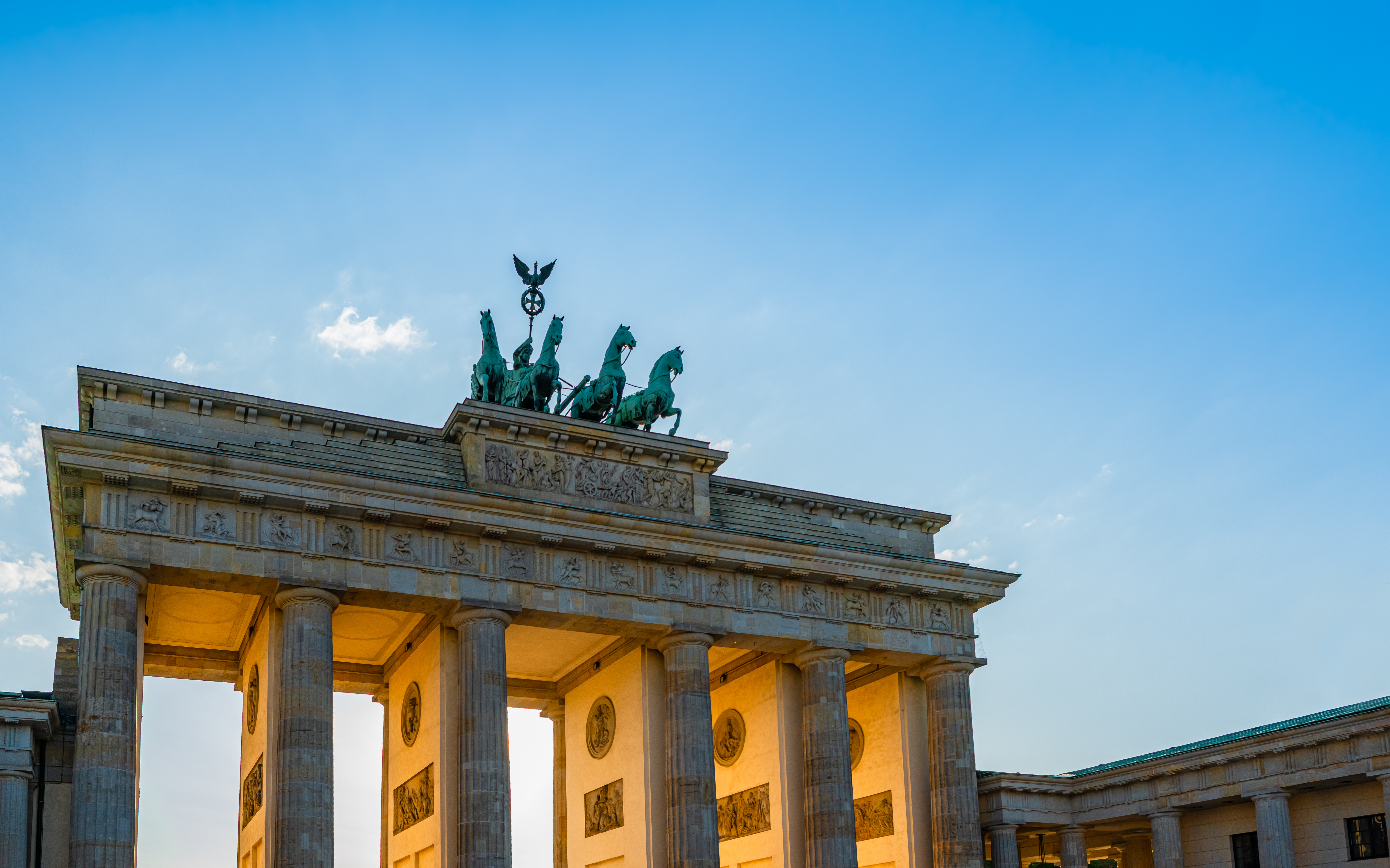 Historisk Brandenburger Tor i Berlin fotograferet ved solnedgang med den karakteristiske quadriga-statue øverst