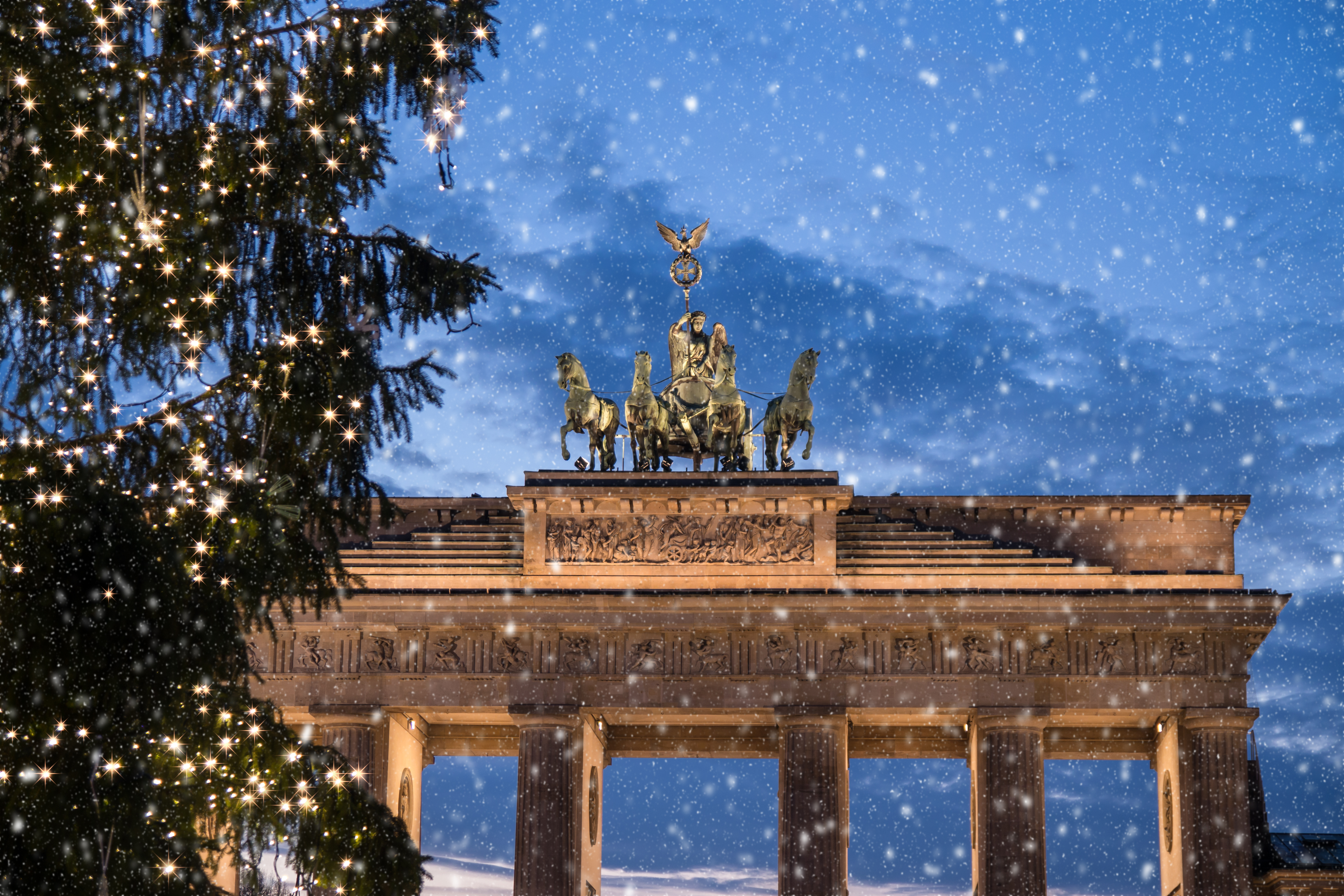 Tysklands berømte Brandenburger Tor med sne, julelys og romantisk vinteraften