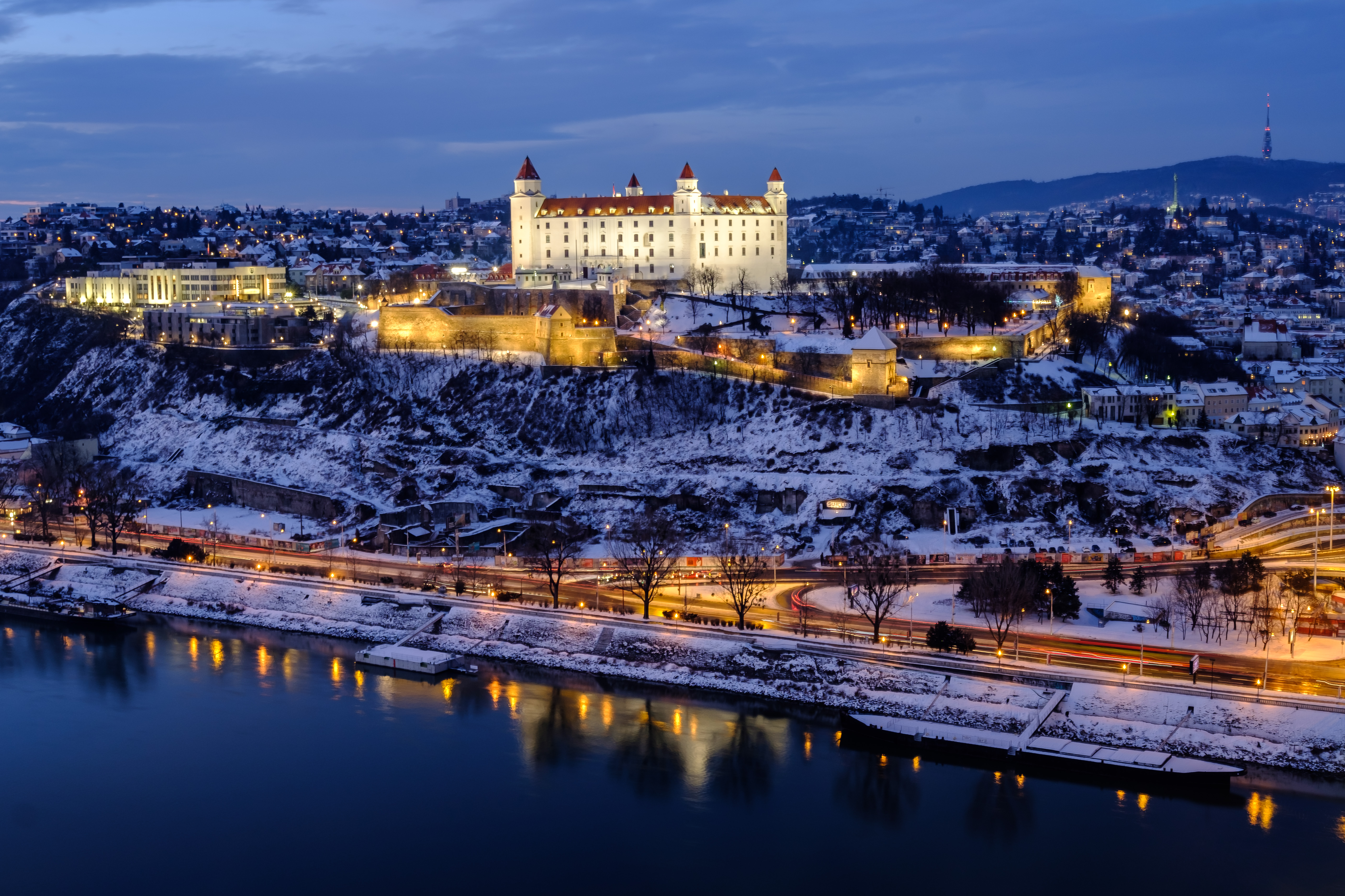Det majestætiske Bratislava Castle ved Donau floden i vintersne med aftenbelysning
