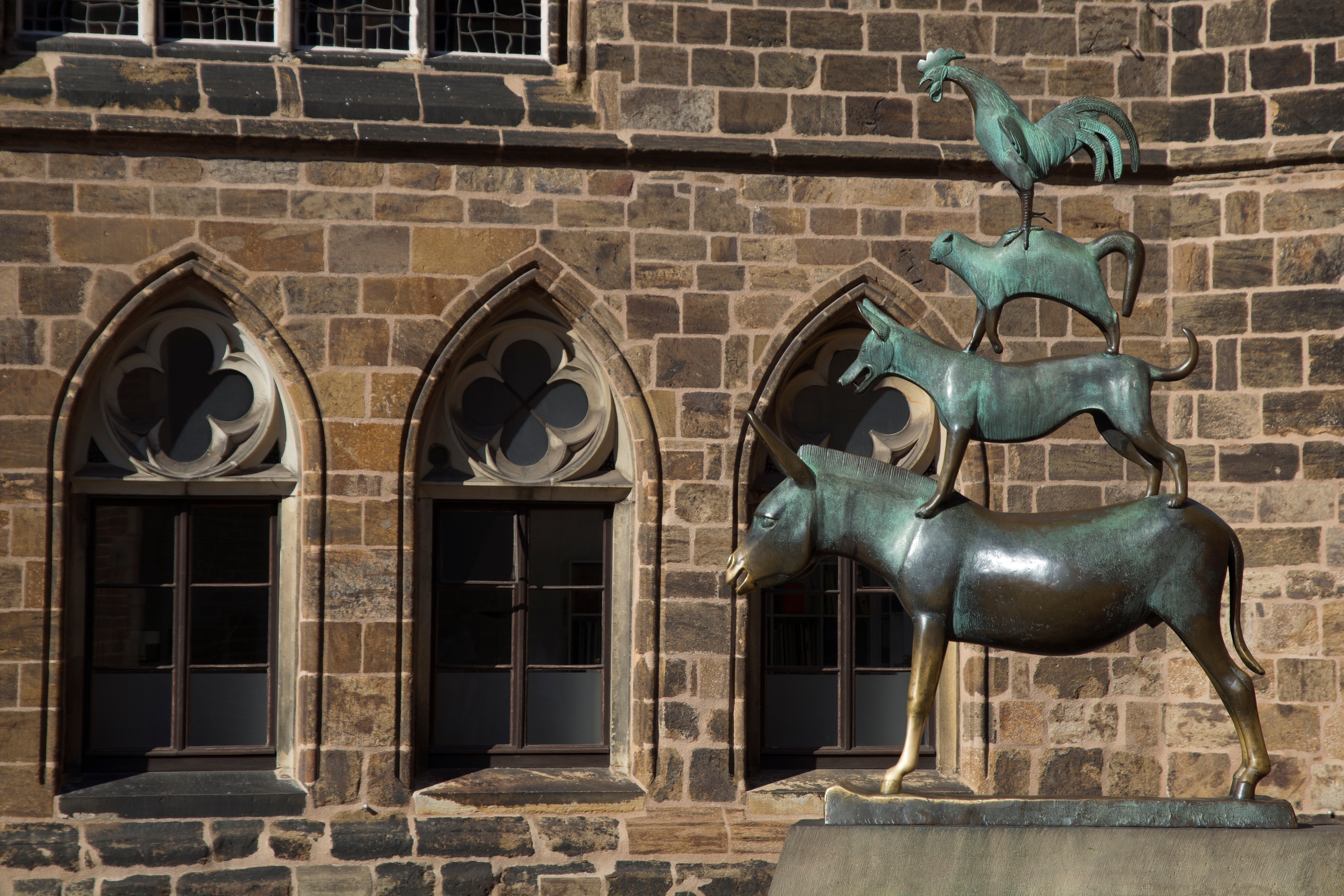 Klassisk Bremen Musikanter bronzeskulptur med stablede dyr foran gotisk arkitektur