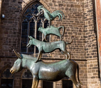 Det kendte Bremer Stadtmusikanten monument med fire bronzedyr stablet ovenpå hinanden foran historisk kirke i Bremen, Niedersachsen
