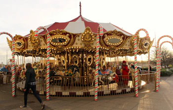 Festlig julekarrusel med klassiske heste og sukkerstangspæle ved Cribbs Causeway i Bristol, England
