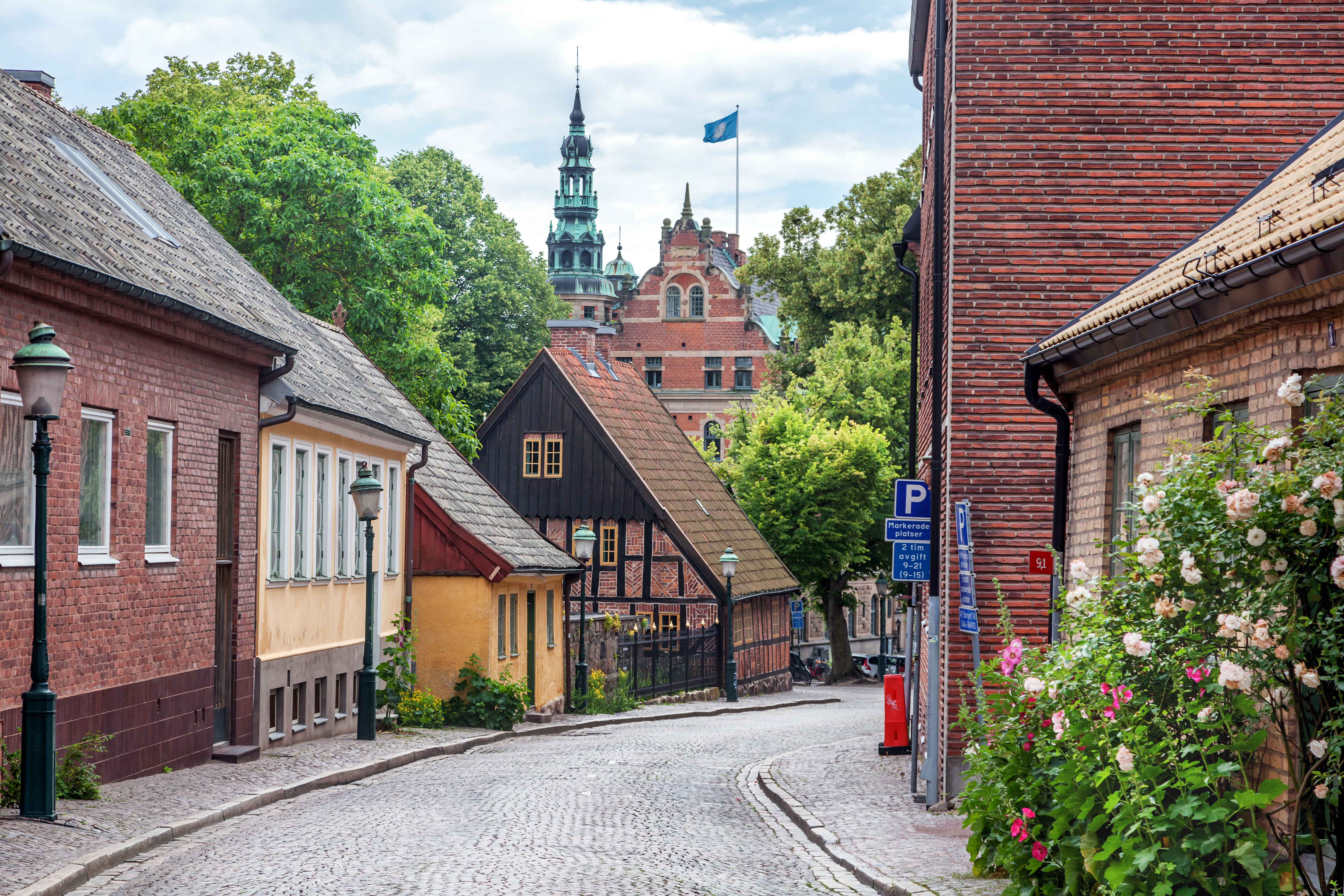 Idyllisk brostensbelagt gade med blomster og traditionel arkitektur i Lund