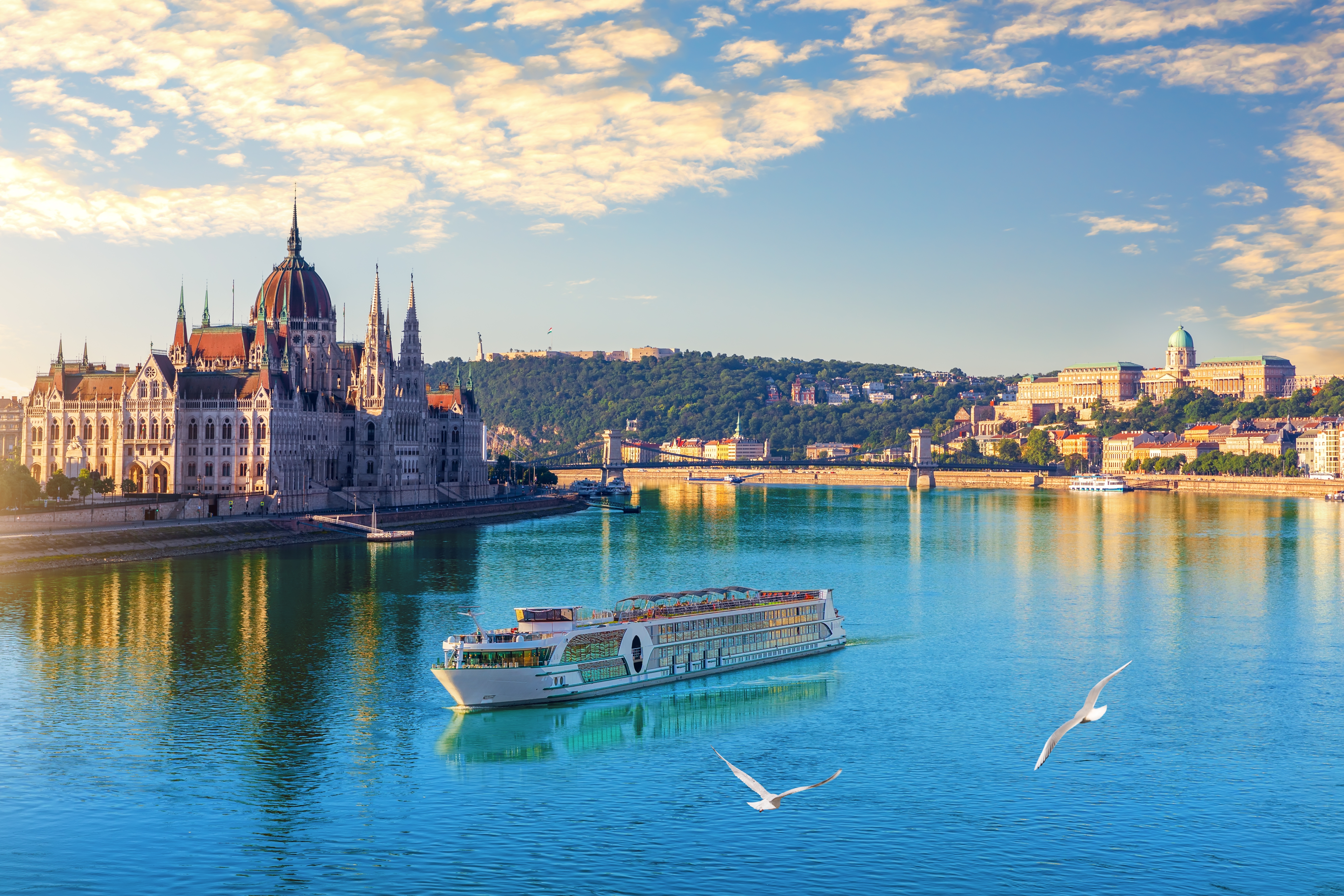 Aftenlig byudsigt over Ungarns parlament ved Donau i Budapest med skibe på floden