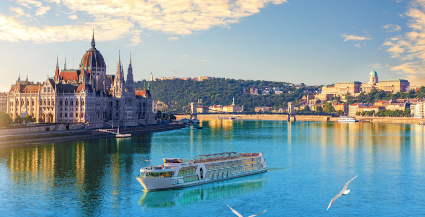 Aftenlig byudsigt over Ungarns parlament ved Donau i Budapest med skibe på floden