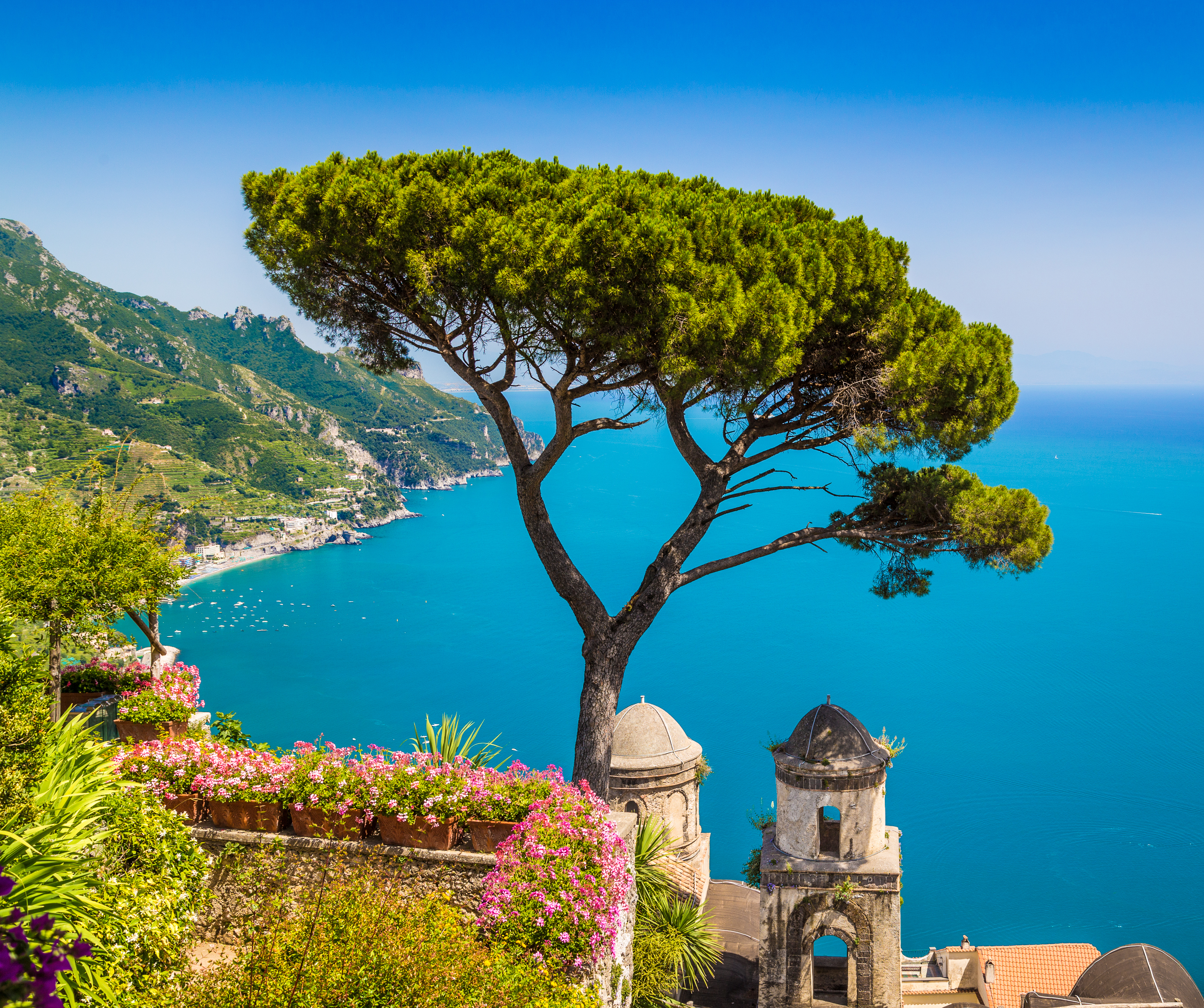 Postkortudsigt over Amalfikysten i Campania med traditionelt klokketårn, pinjetre og det blå Middelhav som rejsedestination