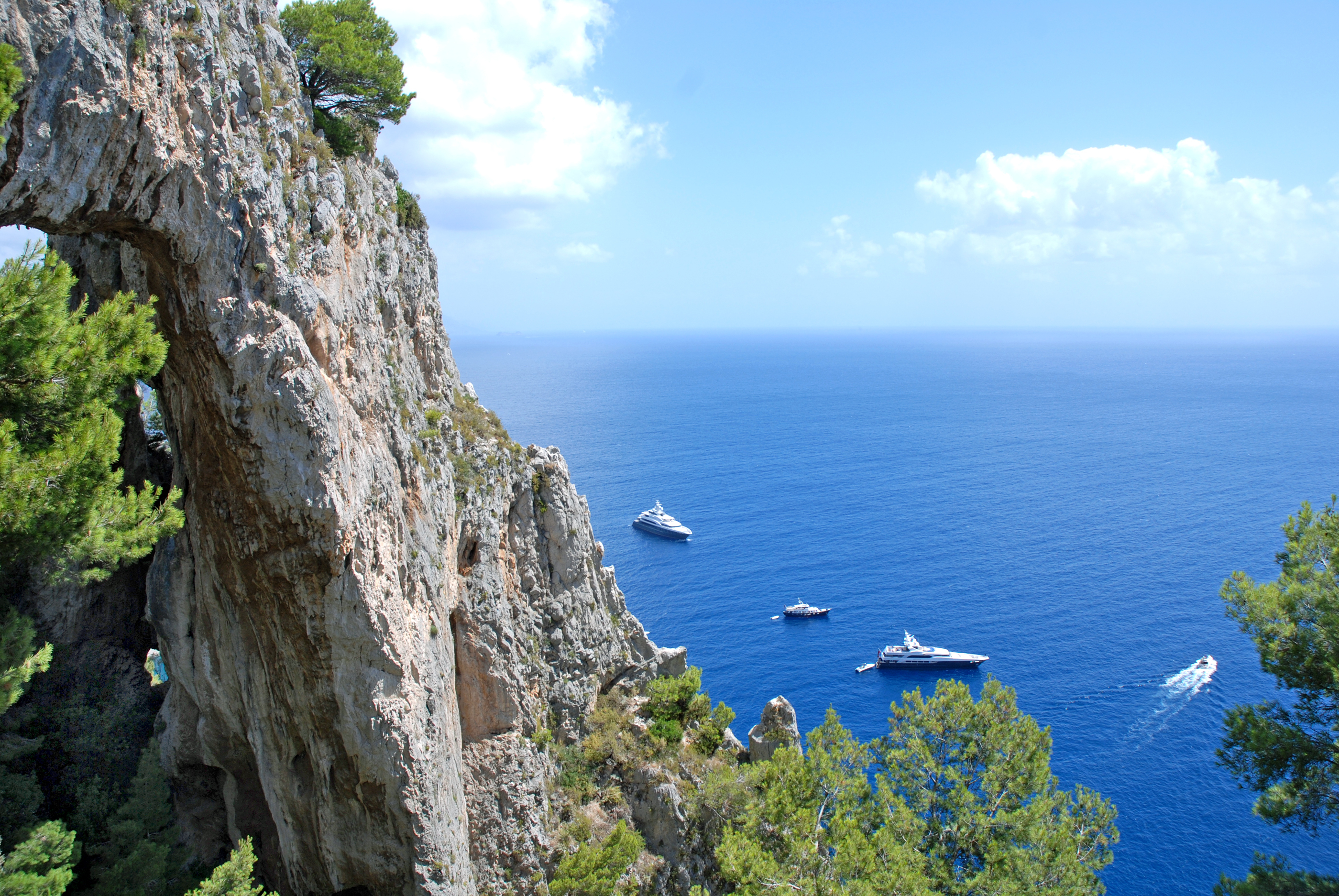 Imponerende bjergkyst på Capri med udsigt til det azurblå Middelhav og elegante yachter