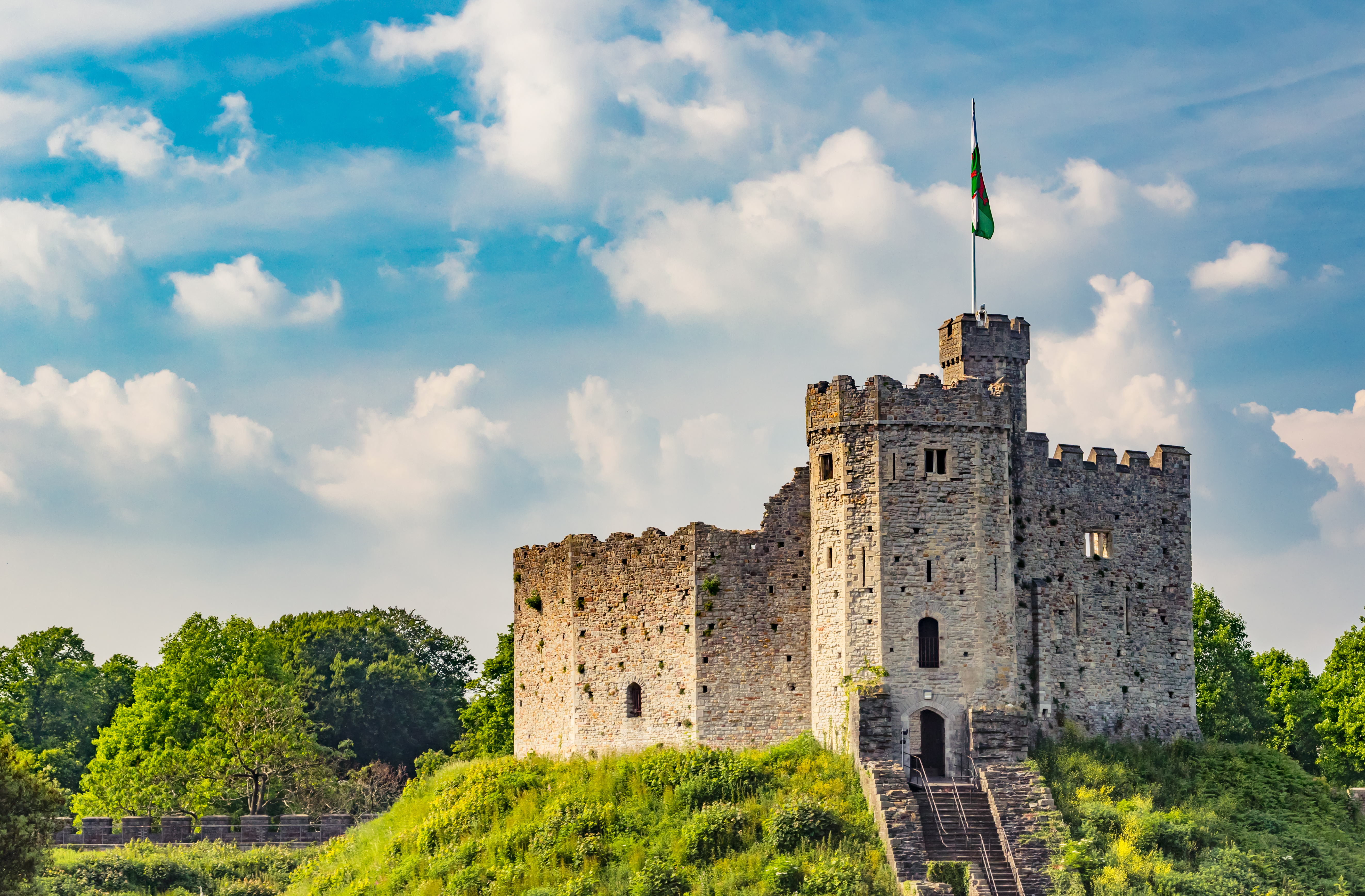 Malerisk udsigt over Cardiff Castle med dets historiske stenmure og tårne omgivet af grønne områder i Wales