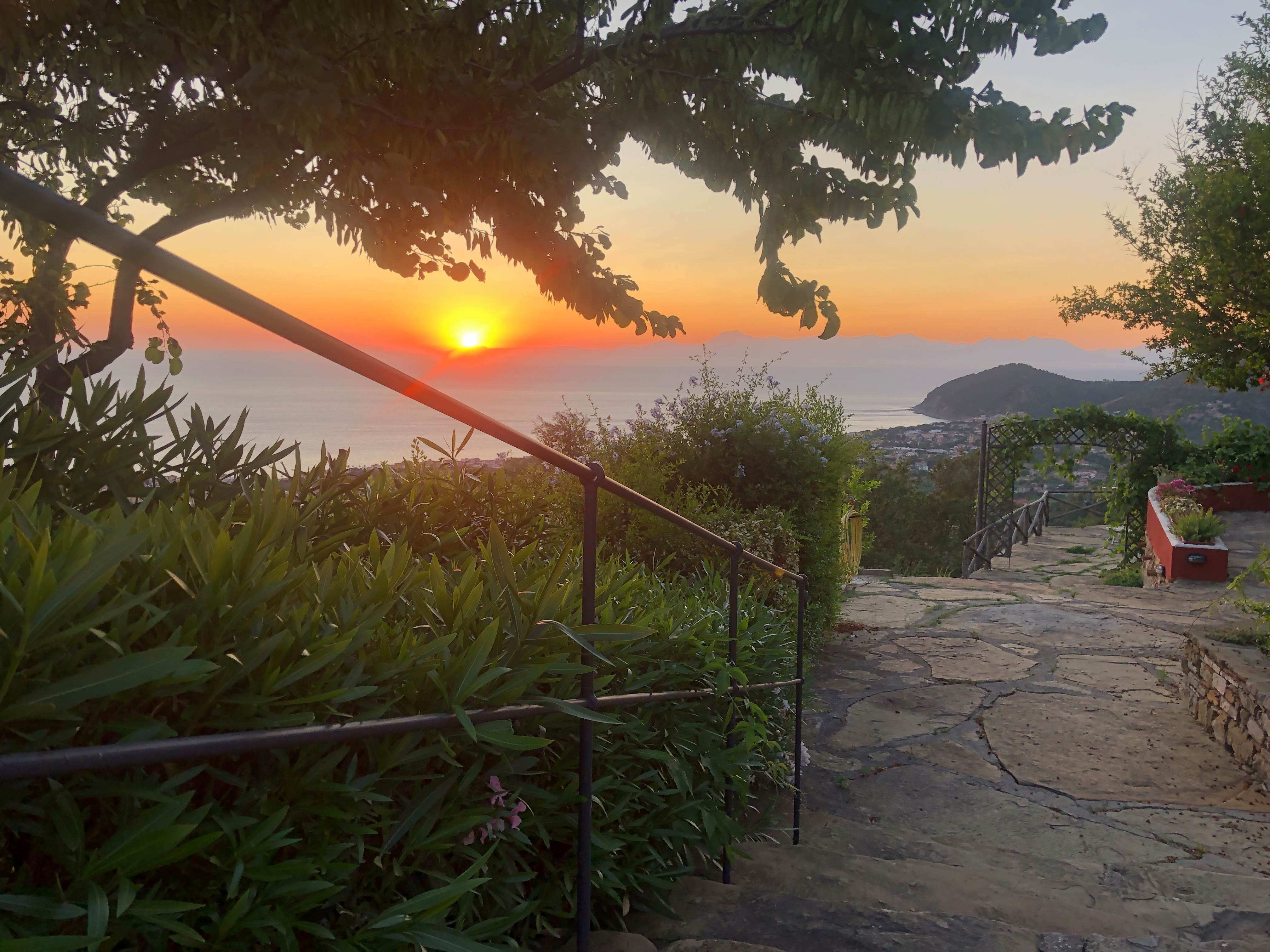 Fantastisk solnedgang over Castellabate og Cilento-kysten i Italien med frodig haveudsigt over Middelhavet