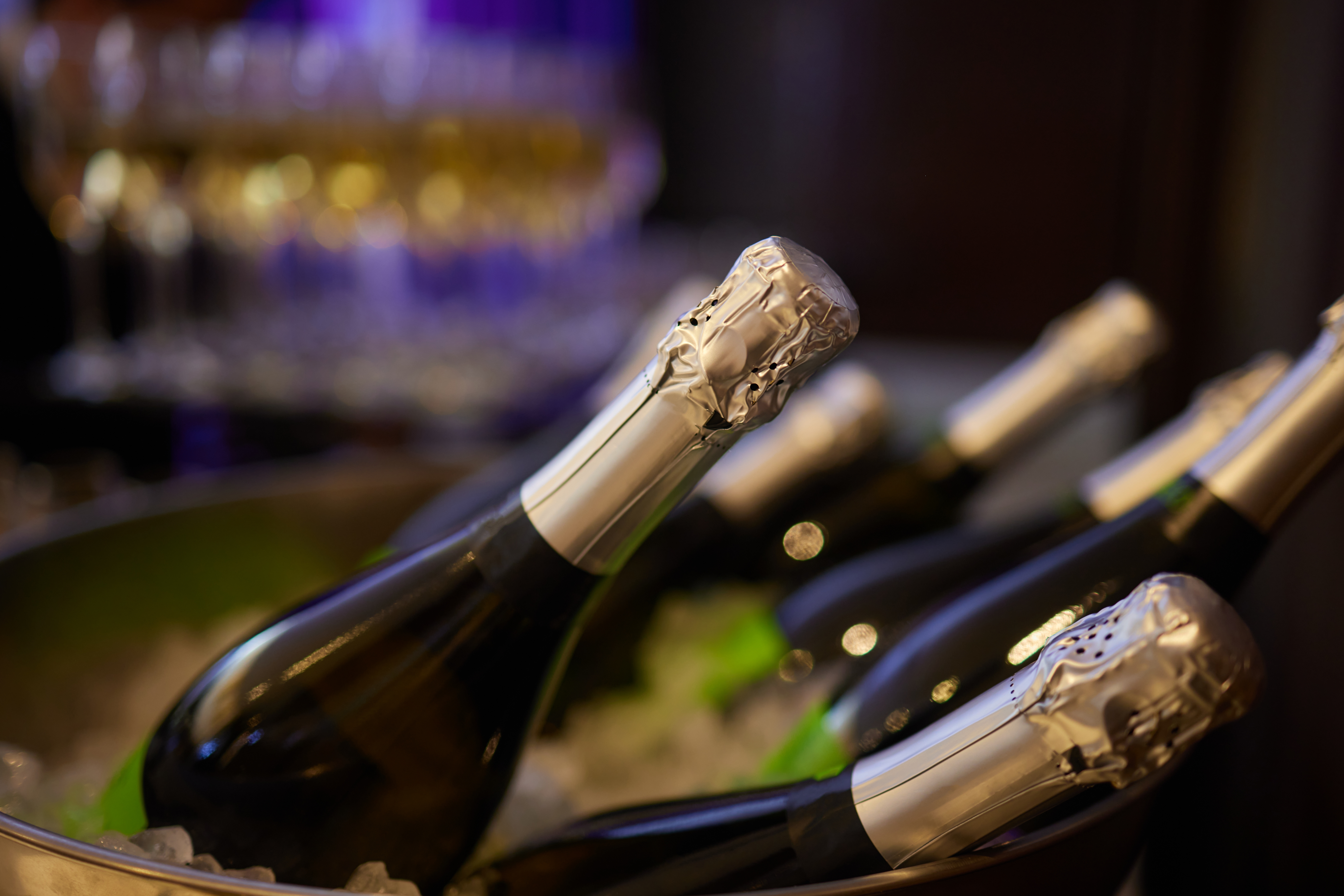 Kolde champagneflasker i isbøtte klar til servering ved eksklusiv fejring og rejseoplevelse